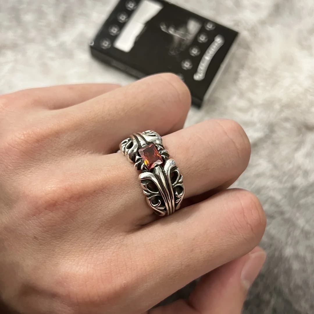 Крупный план серебряного кольца Chrome Hearts K&T с красным камнем на руке