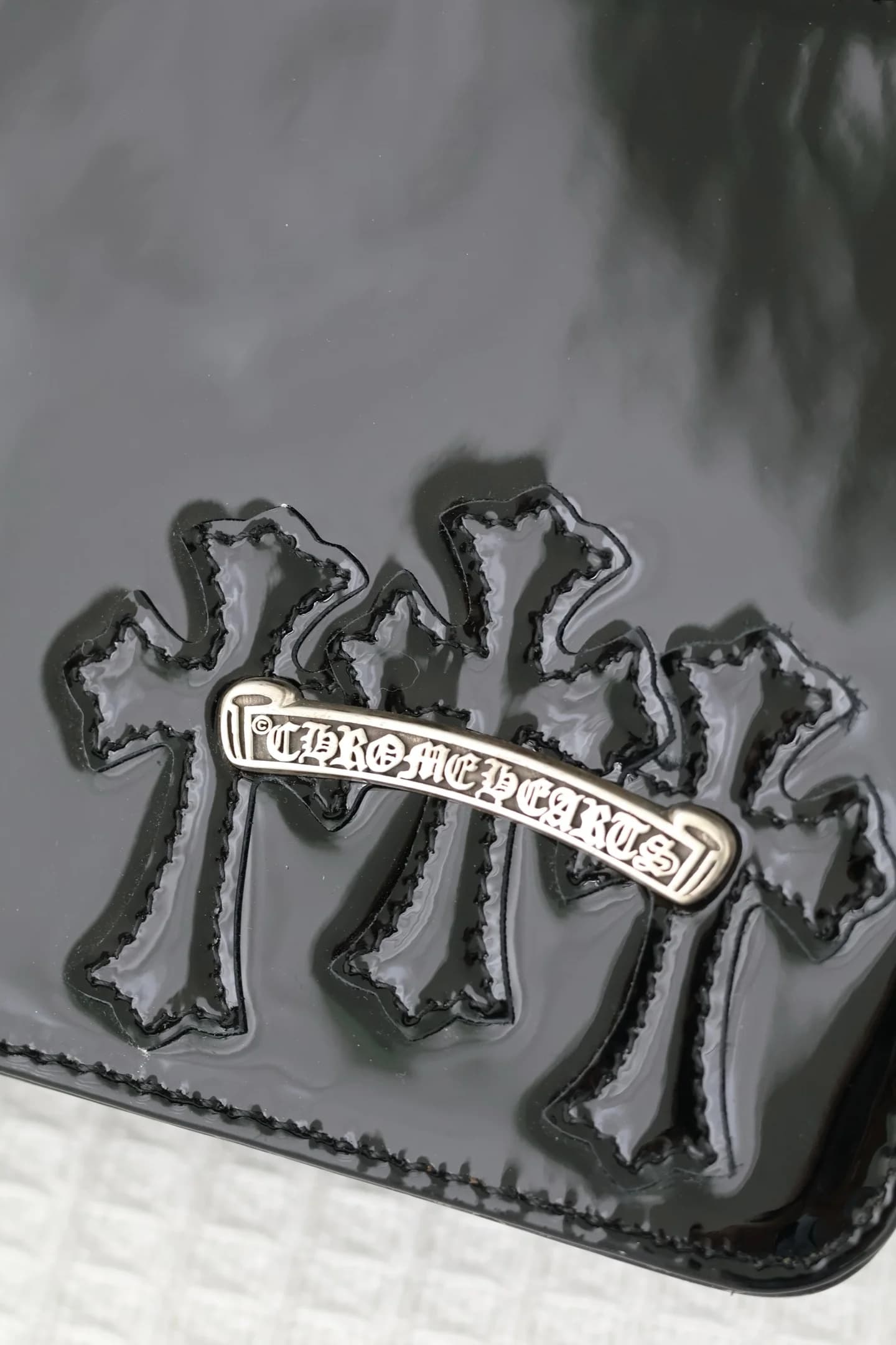 Крупный план кожаных нашивок Cross и серебряного логотипа Chrome Hearts