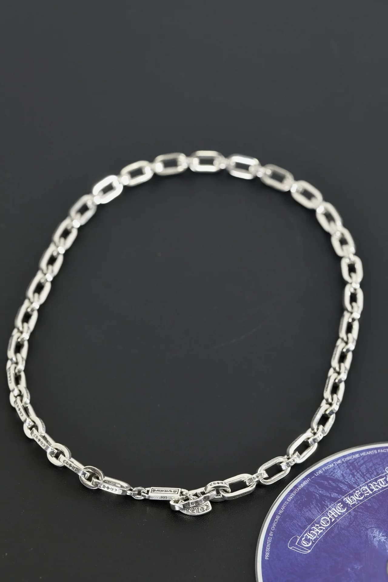 Серебряная цепь Chrome Hearts с фирменным замком на темном фоне