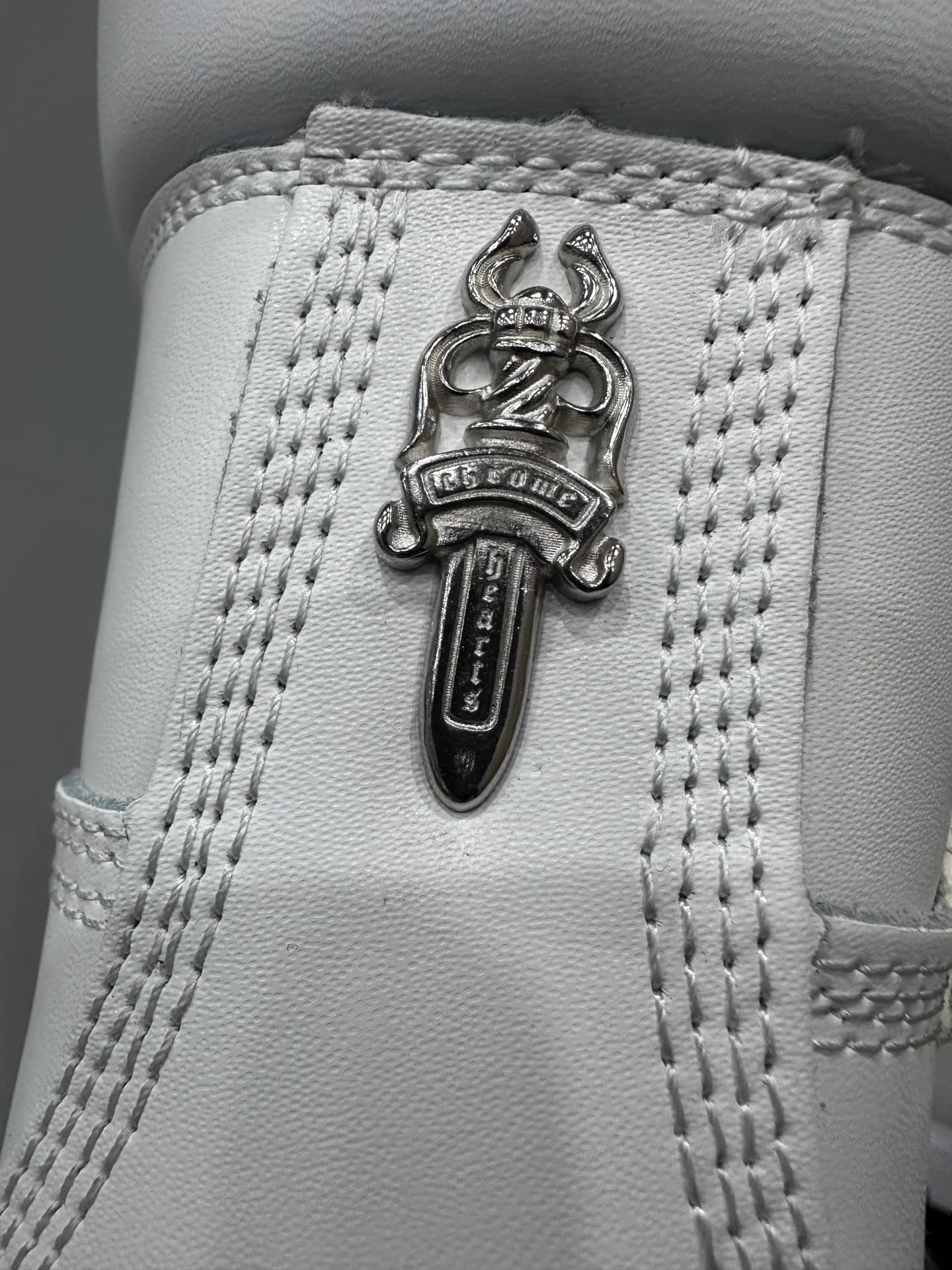 Серебряная деталь в виде кинжала на заднике ботинок Chrome Hearts