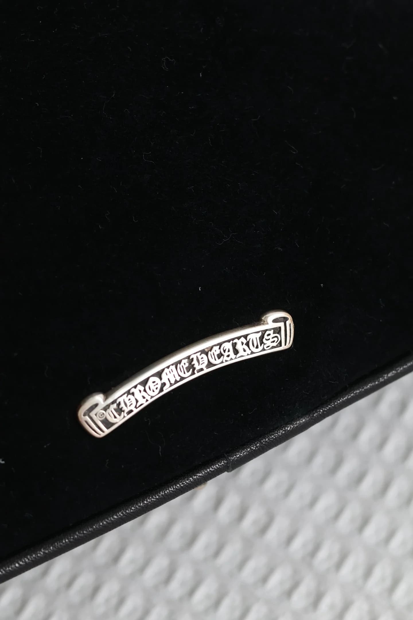 Серебряная плашка с логотипом Chrome Hearts на задней стороне сумки