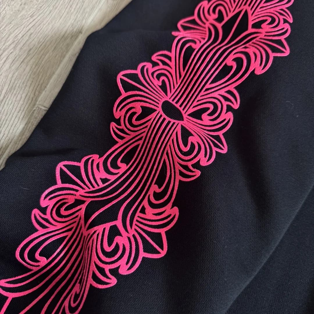 Деталь розового принта с крестами на рукаве худи Chrome Hearts