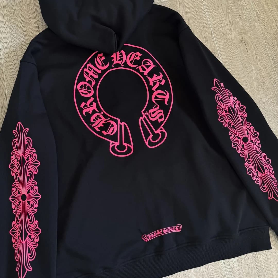 Черное худи Chrome Hearts с розовым принтом на спине, разложенное на полу