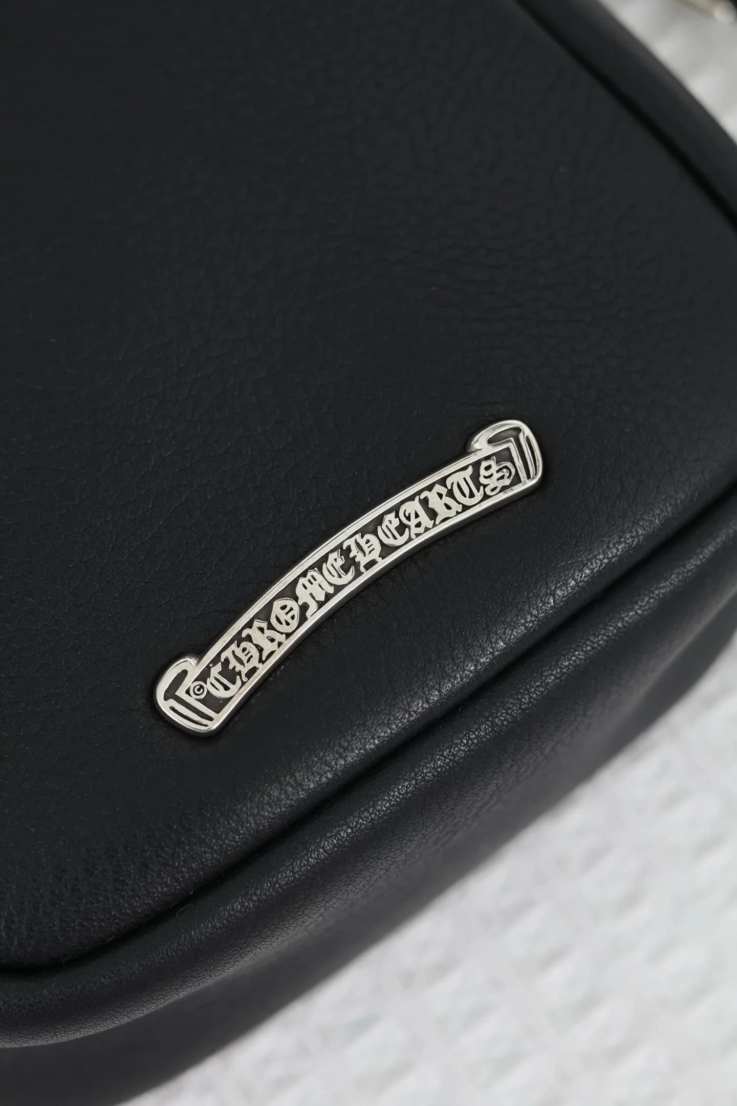 Фирменная серебряная планка с гравировкой Chrome Hearts на задней панели сумки