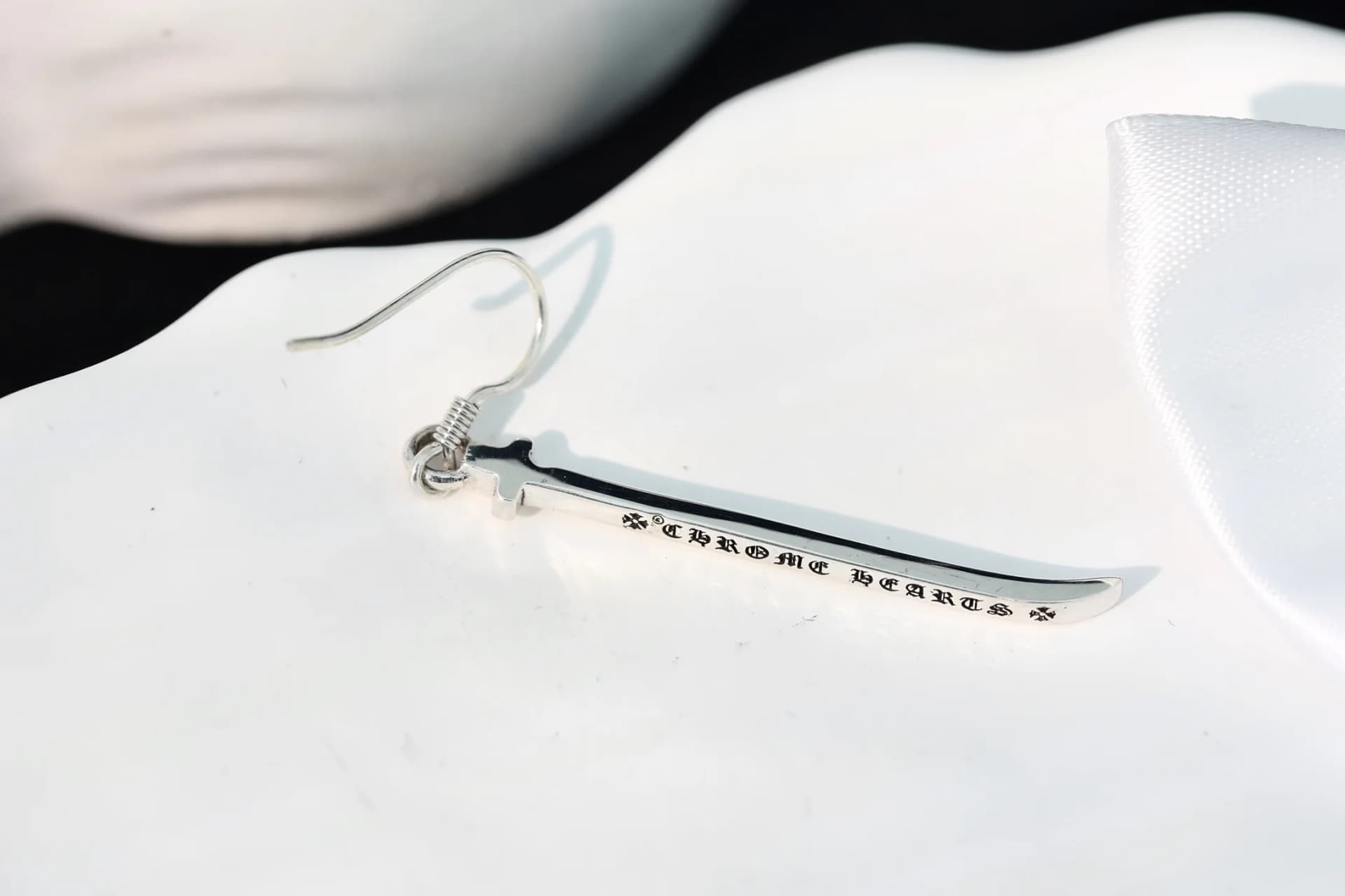 Крупный план фирменной гравировки Chrome Hearts на лезвии меча