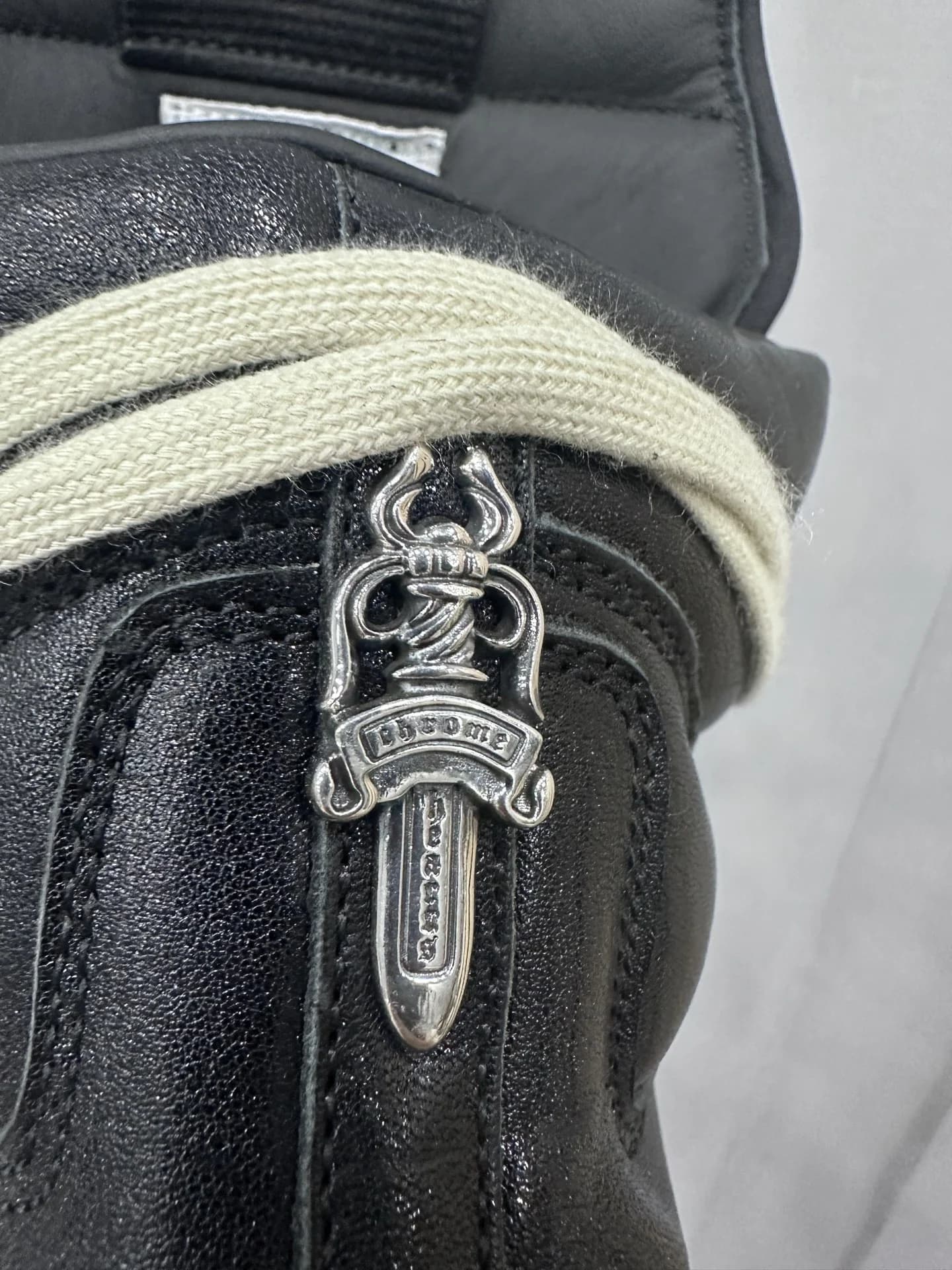 Крупный план серебряного замка-кинжала на кедах Chrome Hearts x Rick Owens Geobasket