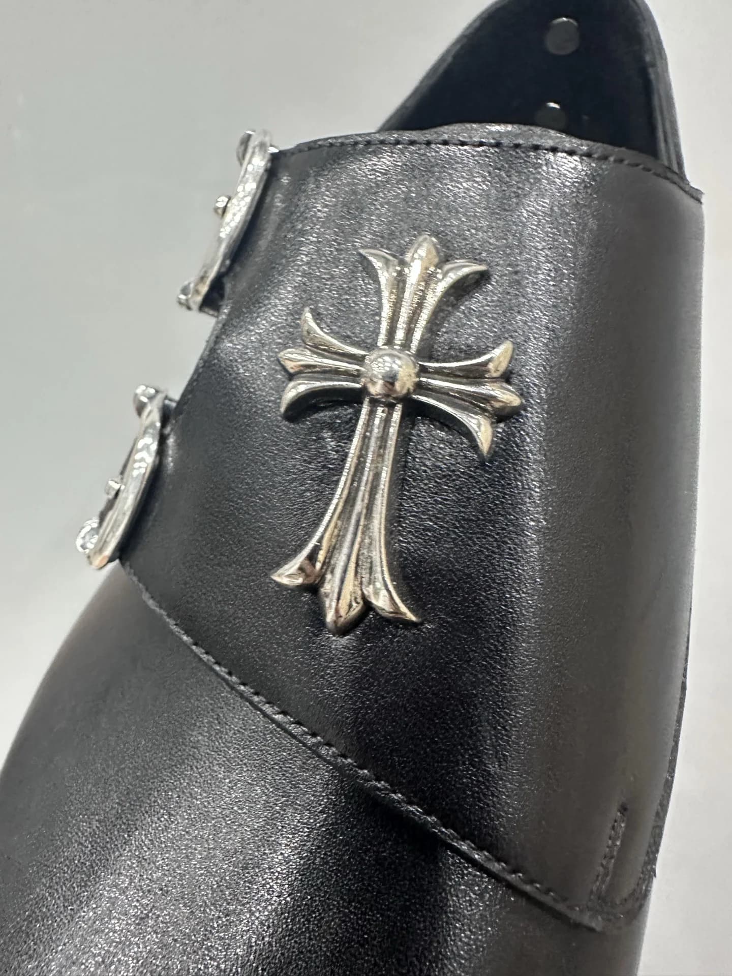 Крупный план серебряного креста на союзке туфель Chrome Hearts x John Lobb