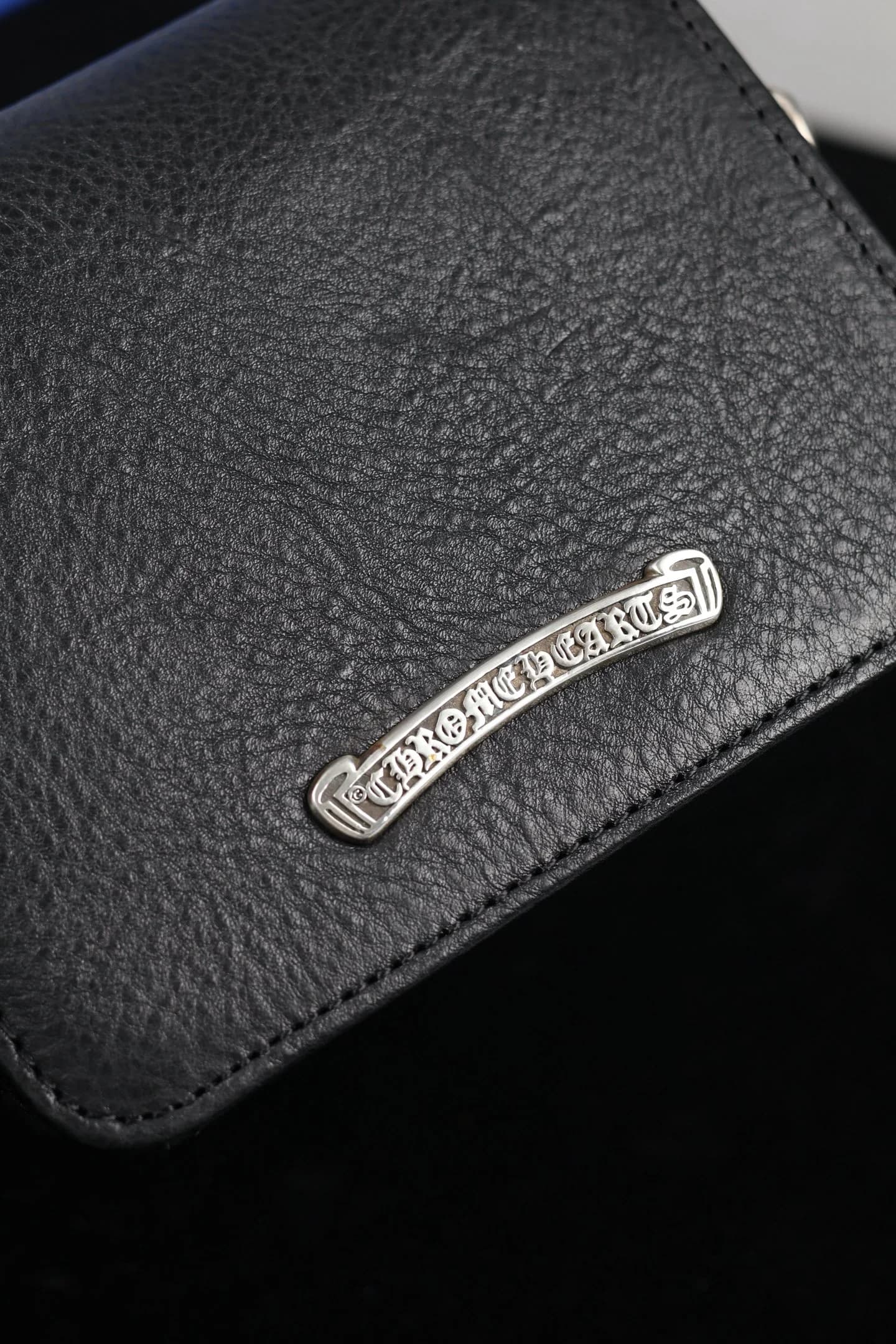Крупный план серебряной плашки с выгравированным логотипом Chrome Hearts