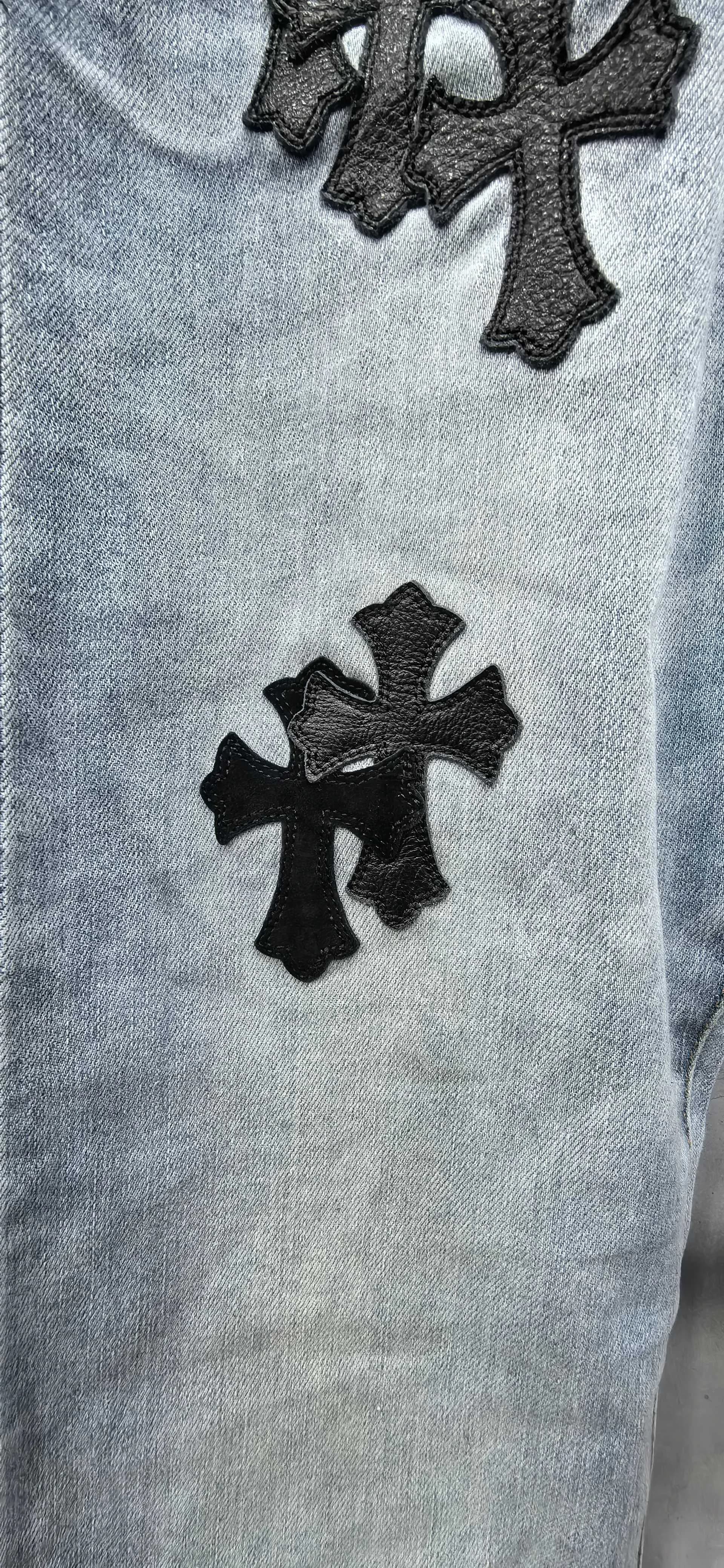 Крупный план нашивки в виде креста из черной кожи на джинсах Chrome Hearts x Levi's 511