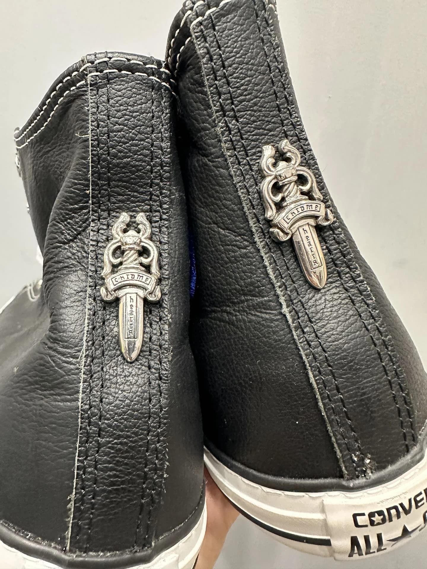 Крупный план серебряного декора в виде кинжалов на задниках кед Chrome Hearts x Converse