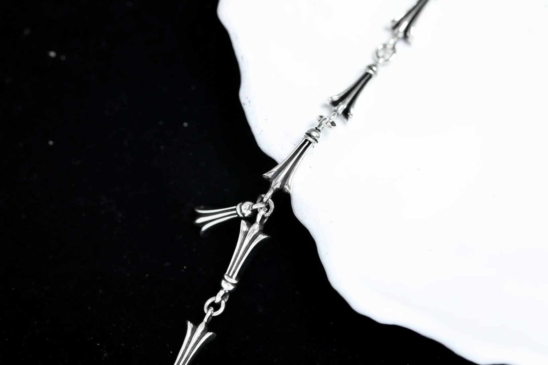 Крупный план звеньев и центральной подвески серебряного браслета Chrome Hearts
