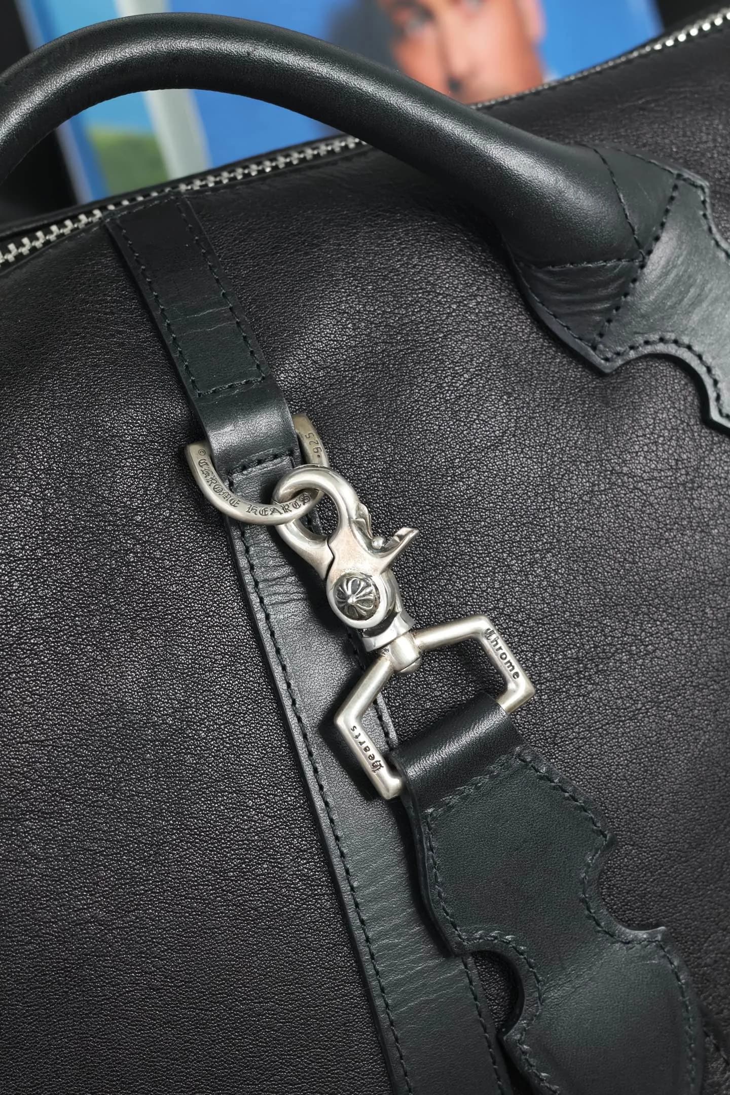 Деталь кожаной ручки и серебряного карабина с гравировкой Chrome Hearts