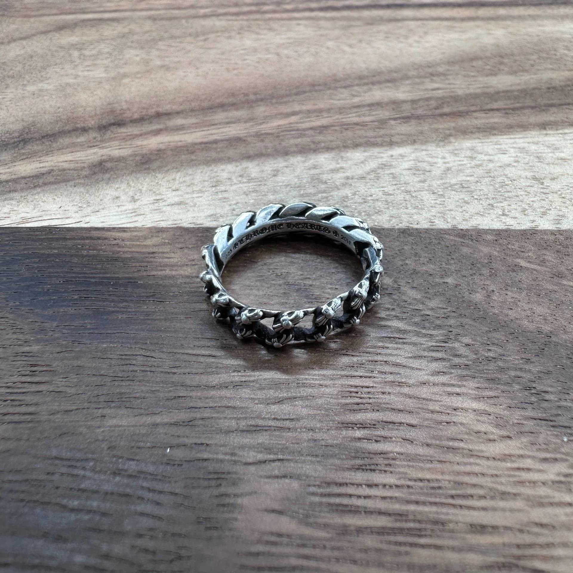 Кольцо Chrome Hearts из серебра 925 пробы на деревянной поверхности, фронтальный ракурс