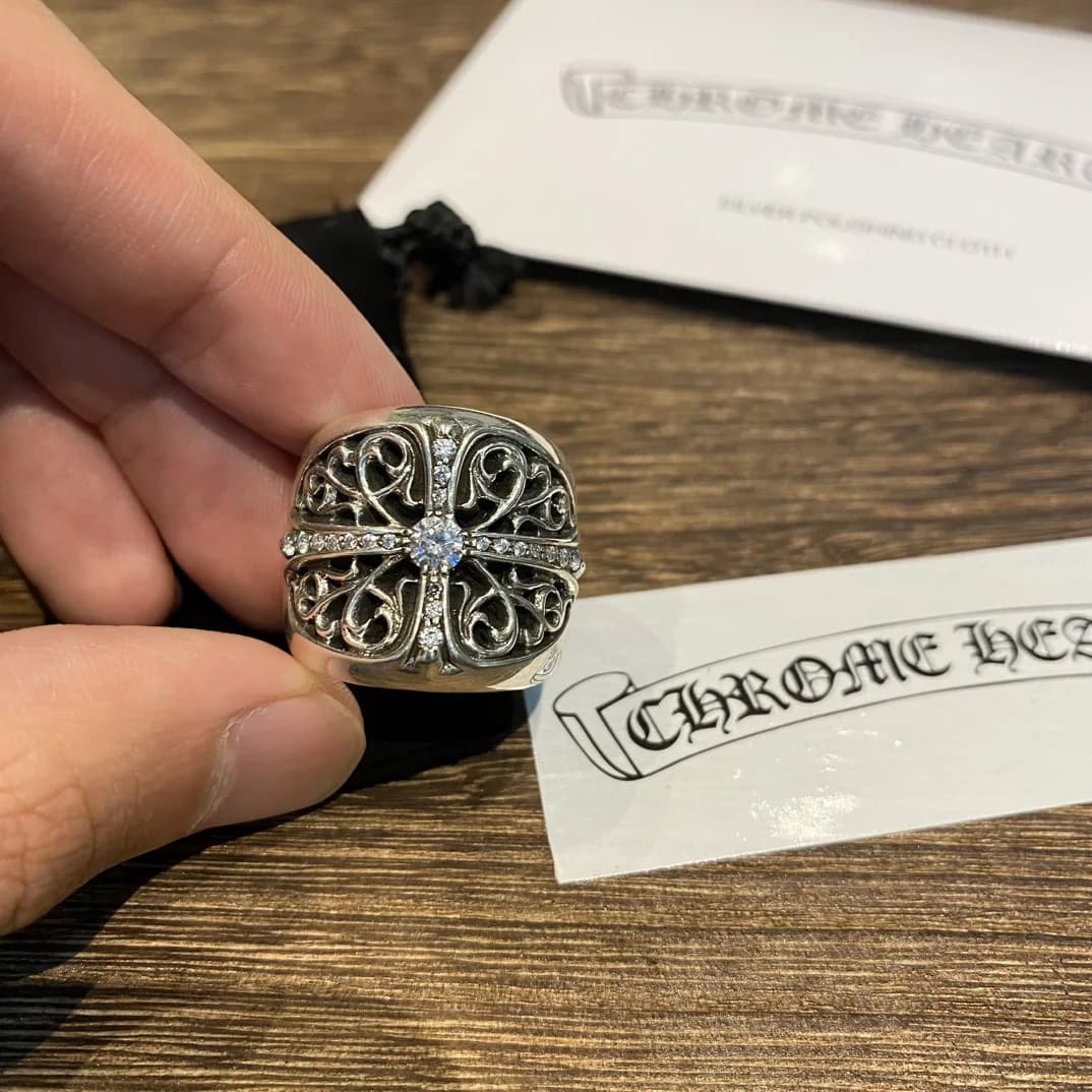 Кольцо Chrome Hearts Oval Cross в руке рядом с салфеткой для полировки