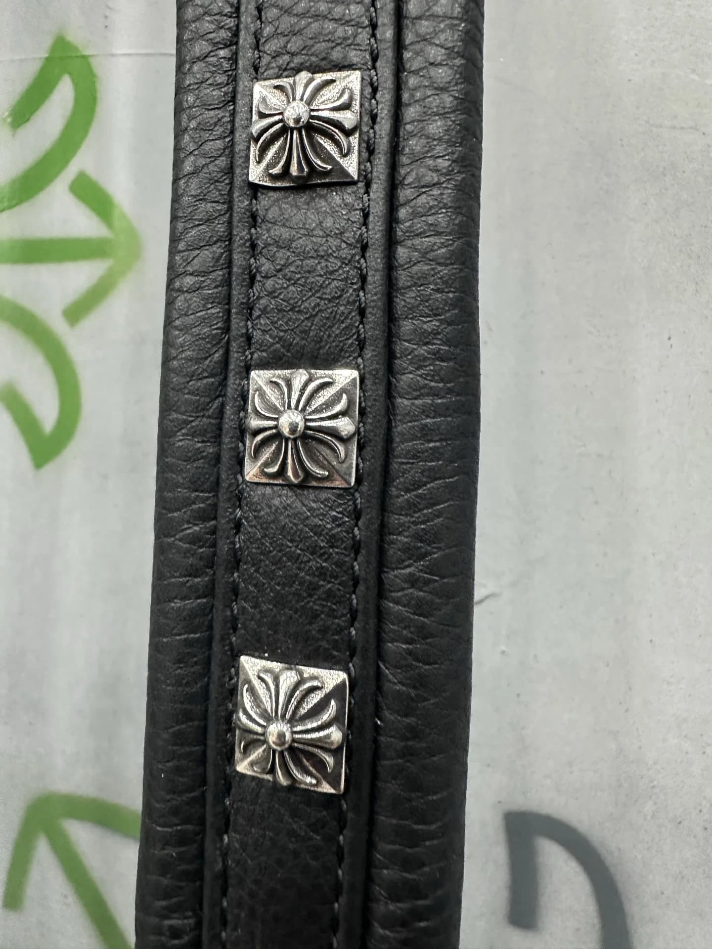 Крупный план квадратных серебряных заклепок с крестами Chrome Hearts