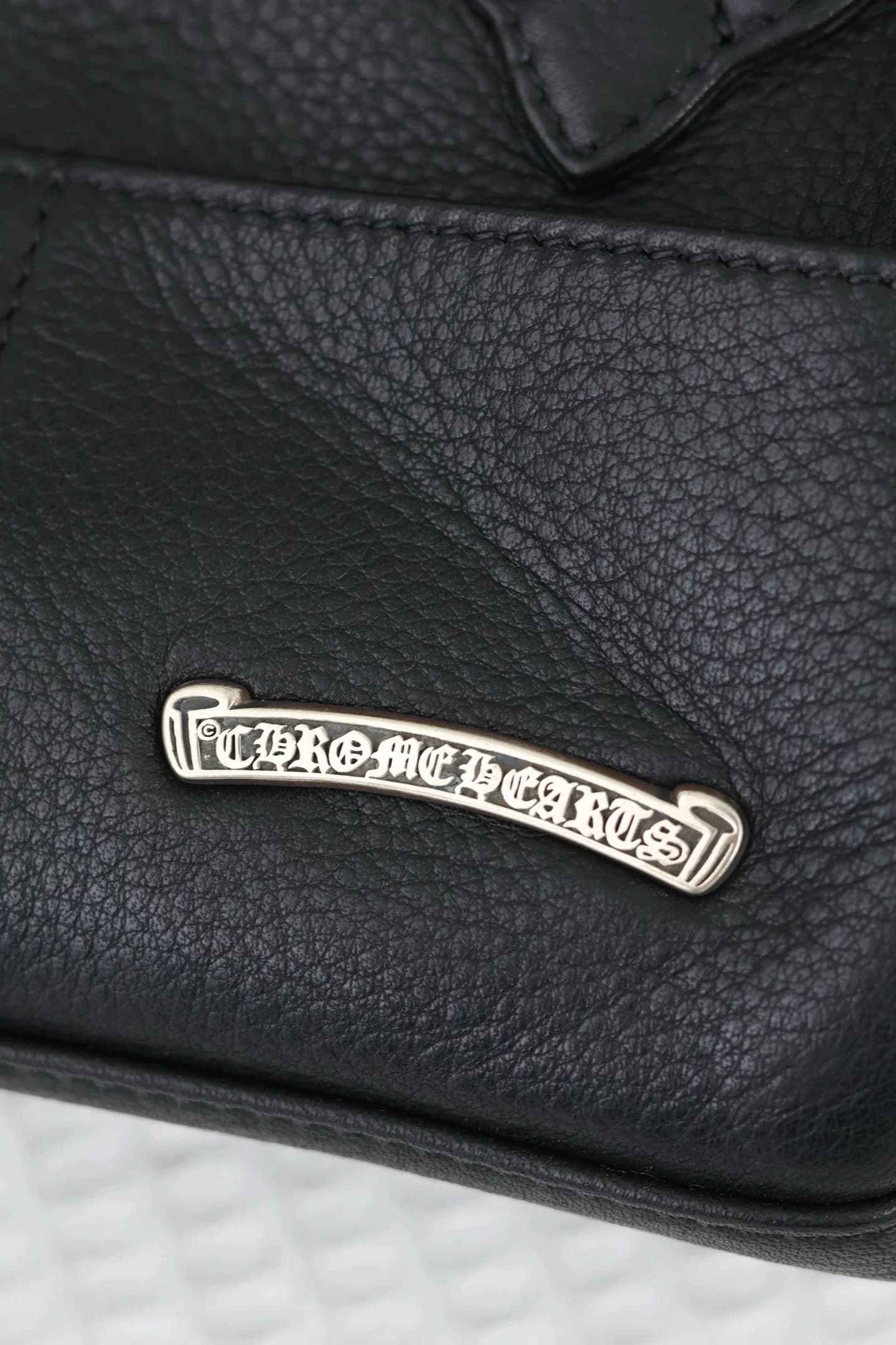 Макросъемка серебряной пластины с гравировкой Chrome Hearts
