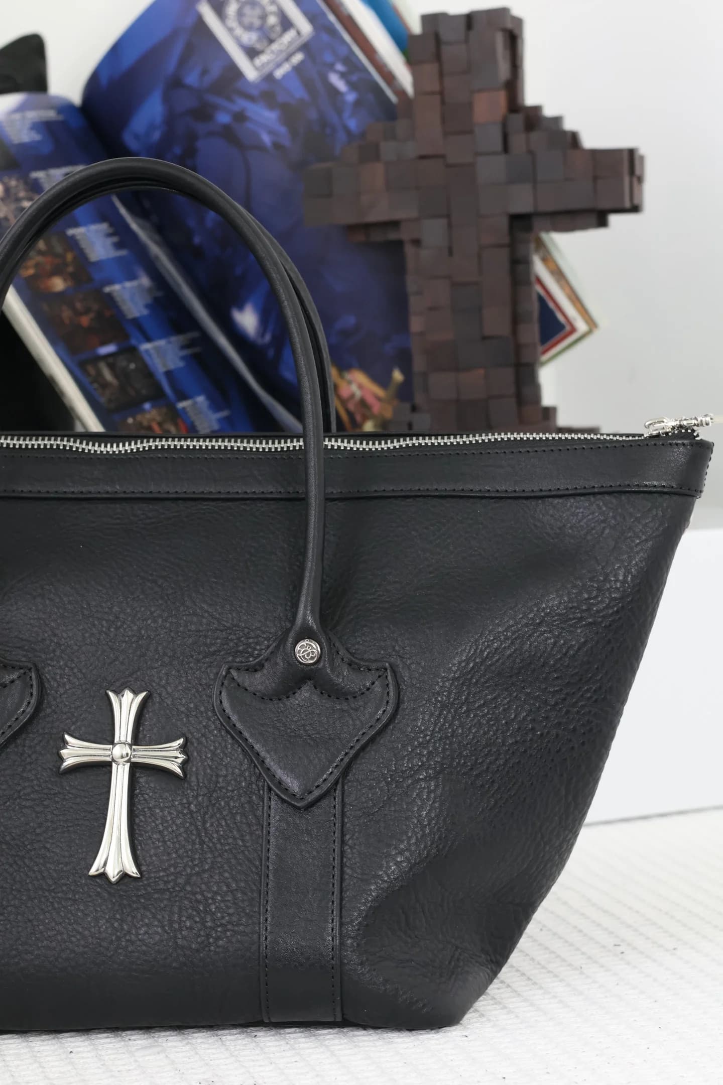 Крупный план ручки и серебряного креста CH Cross на сумке Chrome Hearts