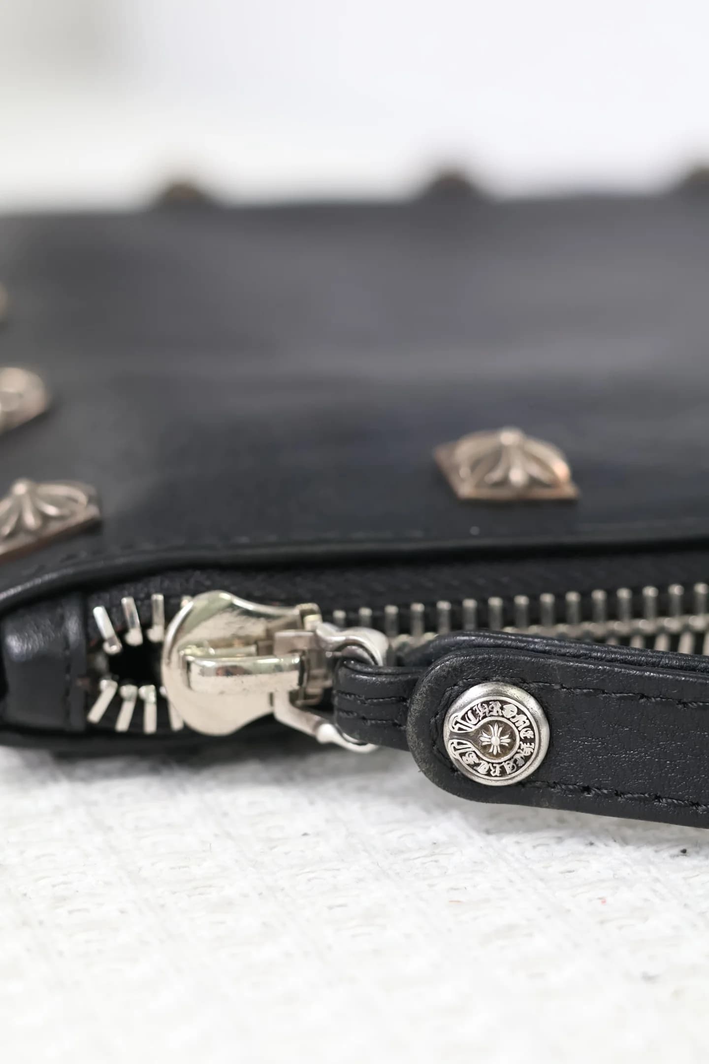 Крупный план металлической молнии и заклепки клатча Chrome Hearts