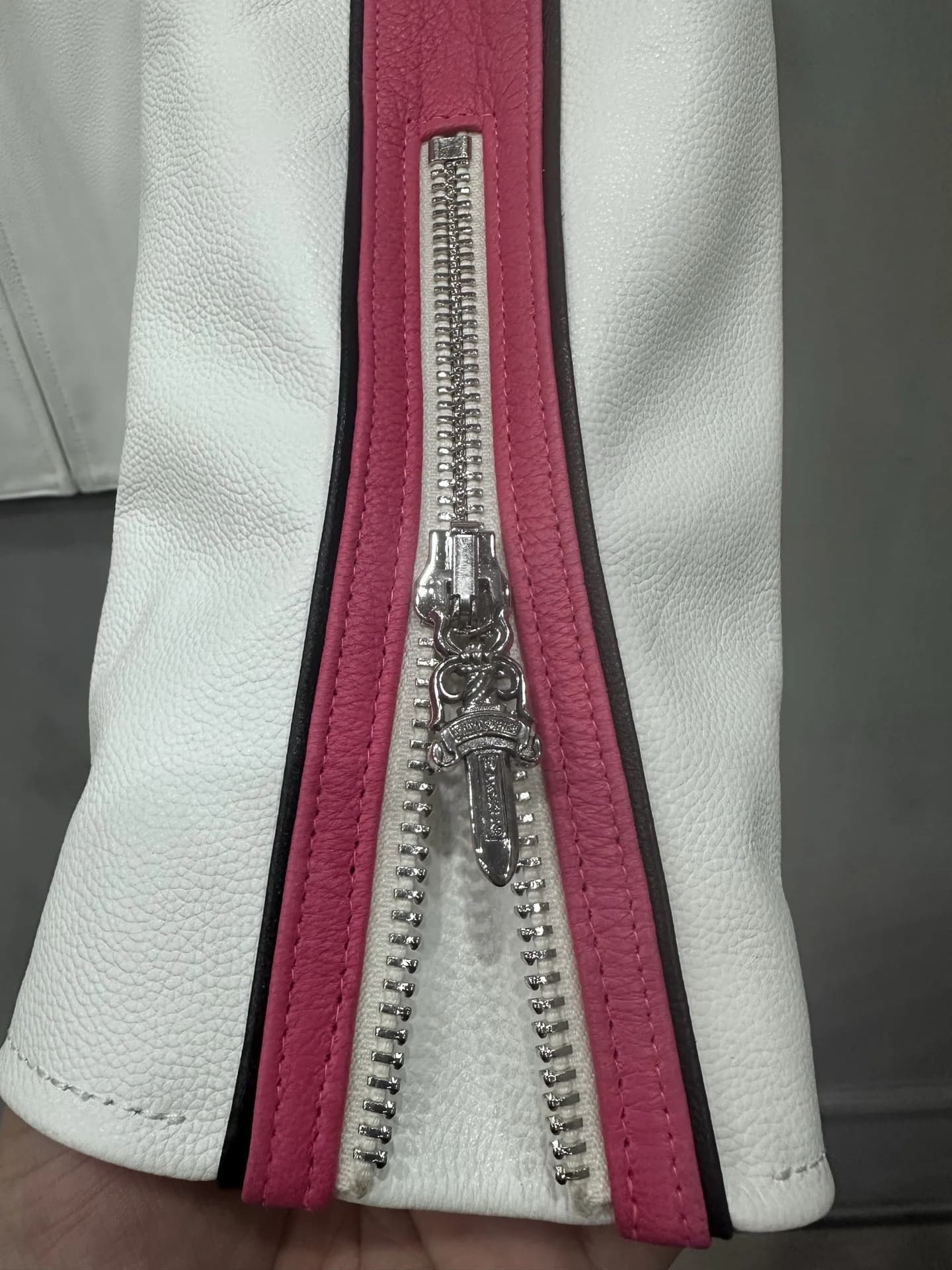Деталь молнии на рукаве белой кожаной куртки Chrome Hearts