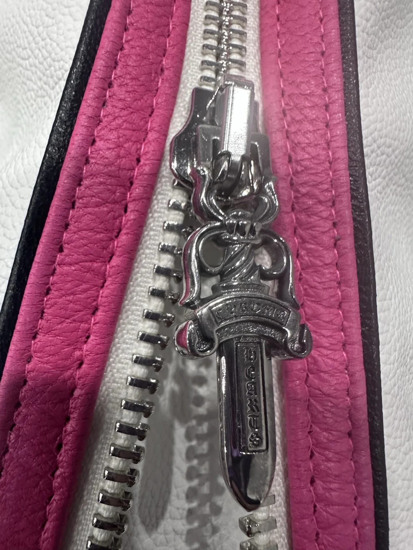 Крупный план серебряного пуллера в виде кинжала на молнии Chrome Hearts