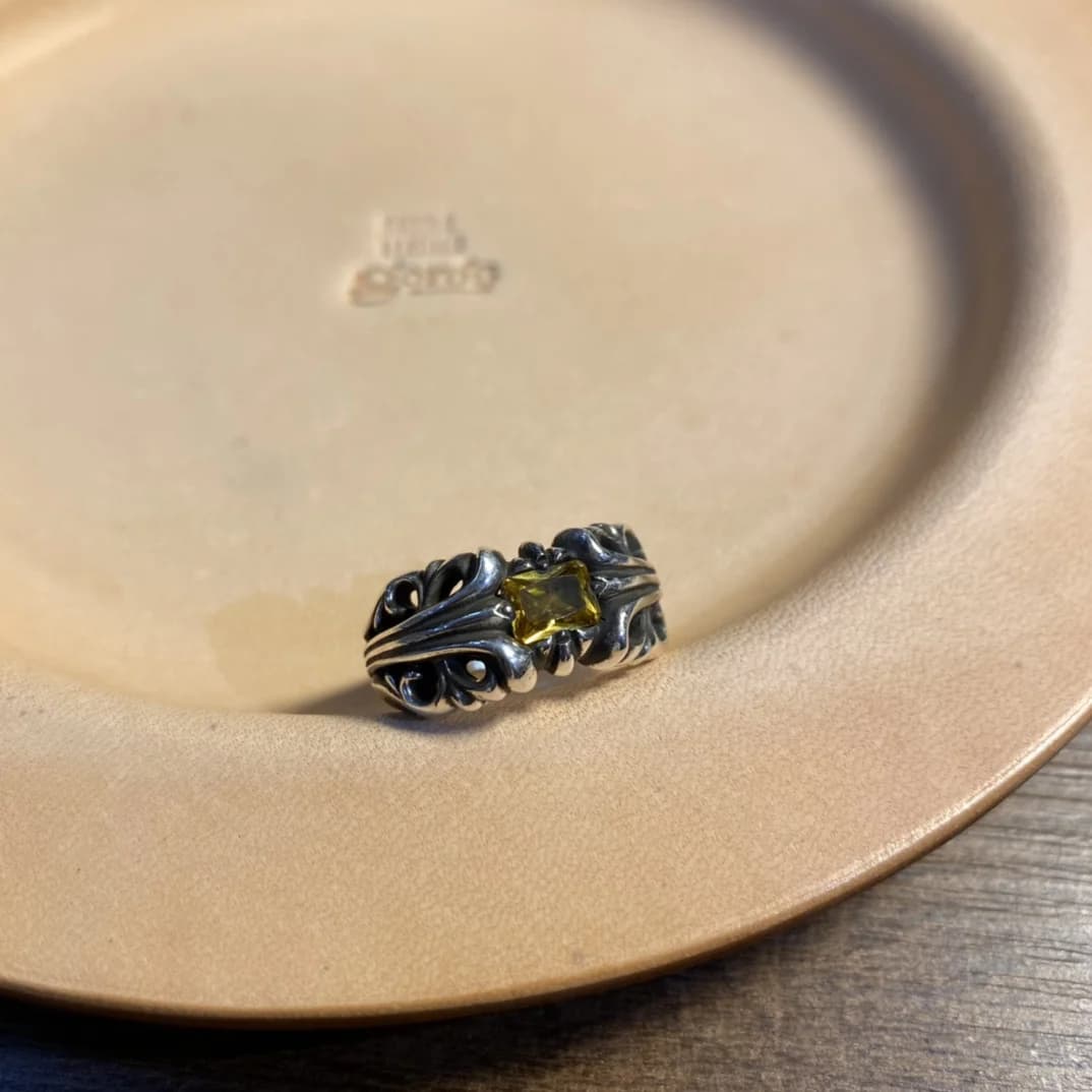 Серебряное кольцо с жёлтым кристаллом на кожаной подставке