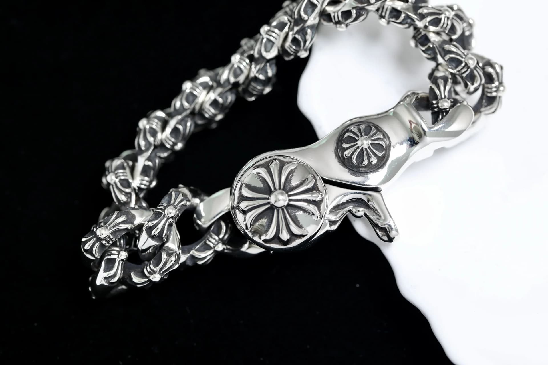 Крупный план замка-карабина браслета Chrome Hearts с гравировкой креста
