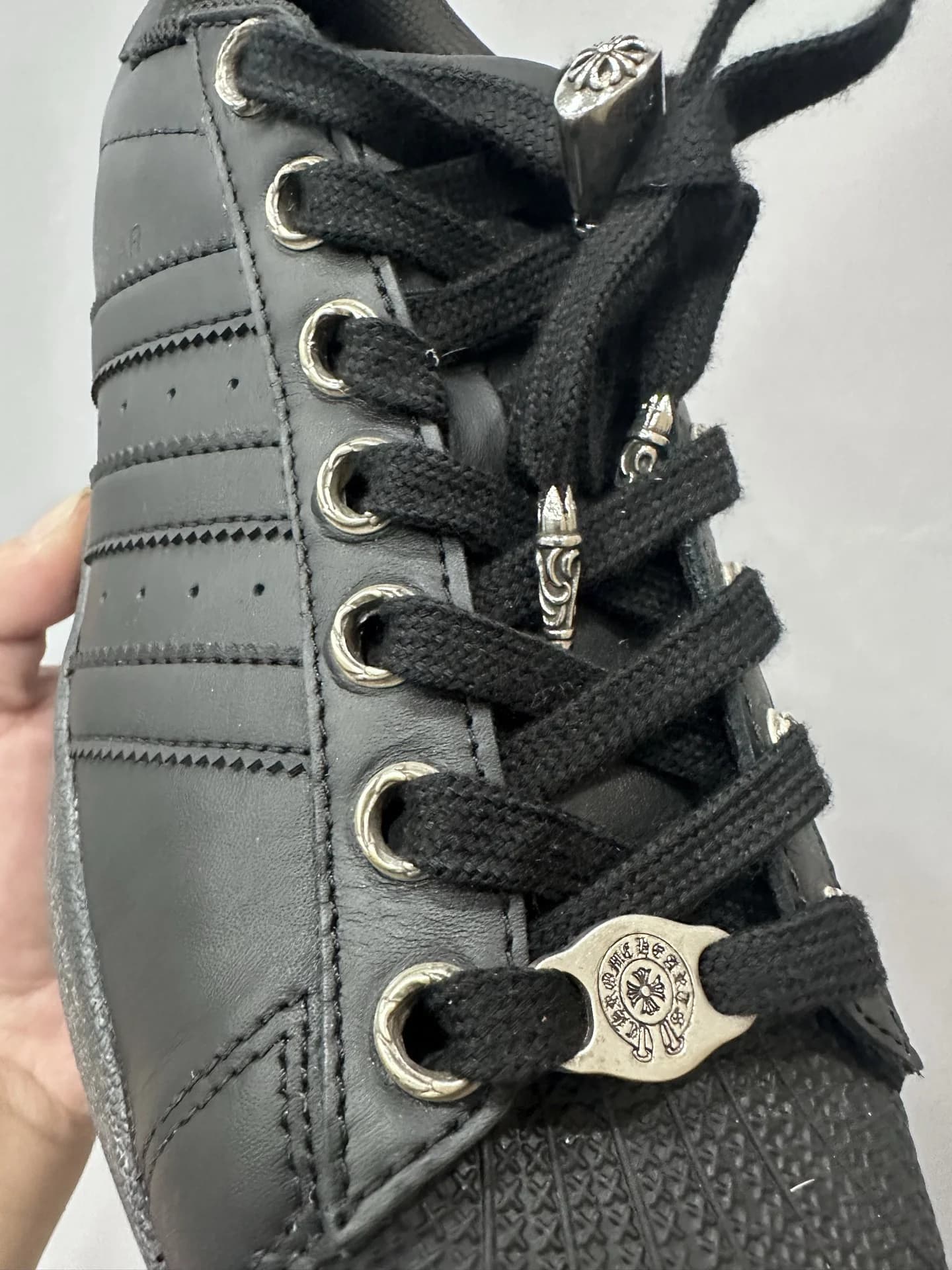 Деталь шнуровки кед Chrome Hearts x Adidas Superstar с серебряной фурнитурой