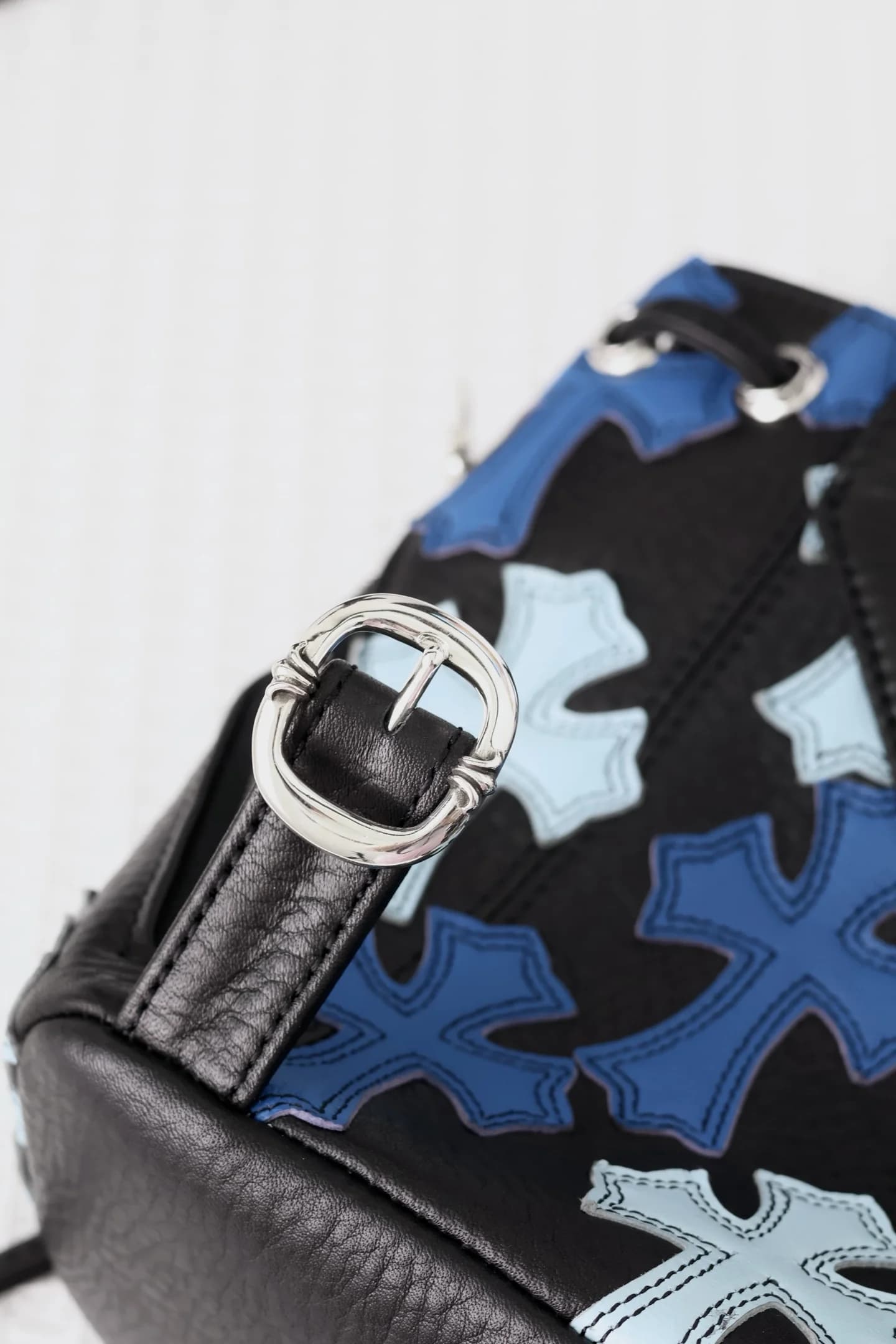 Крупный план серебряной пряжки ремня с гравировкой Chrome Hearts