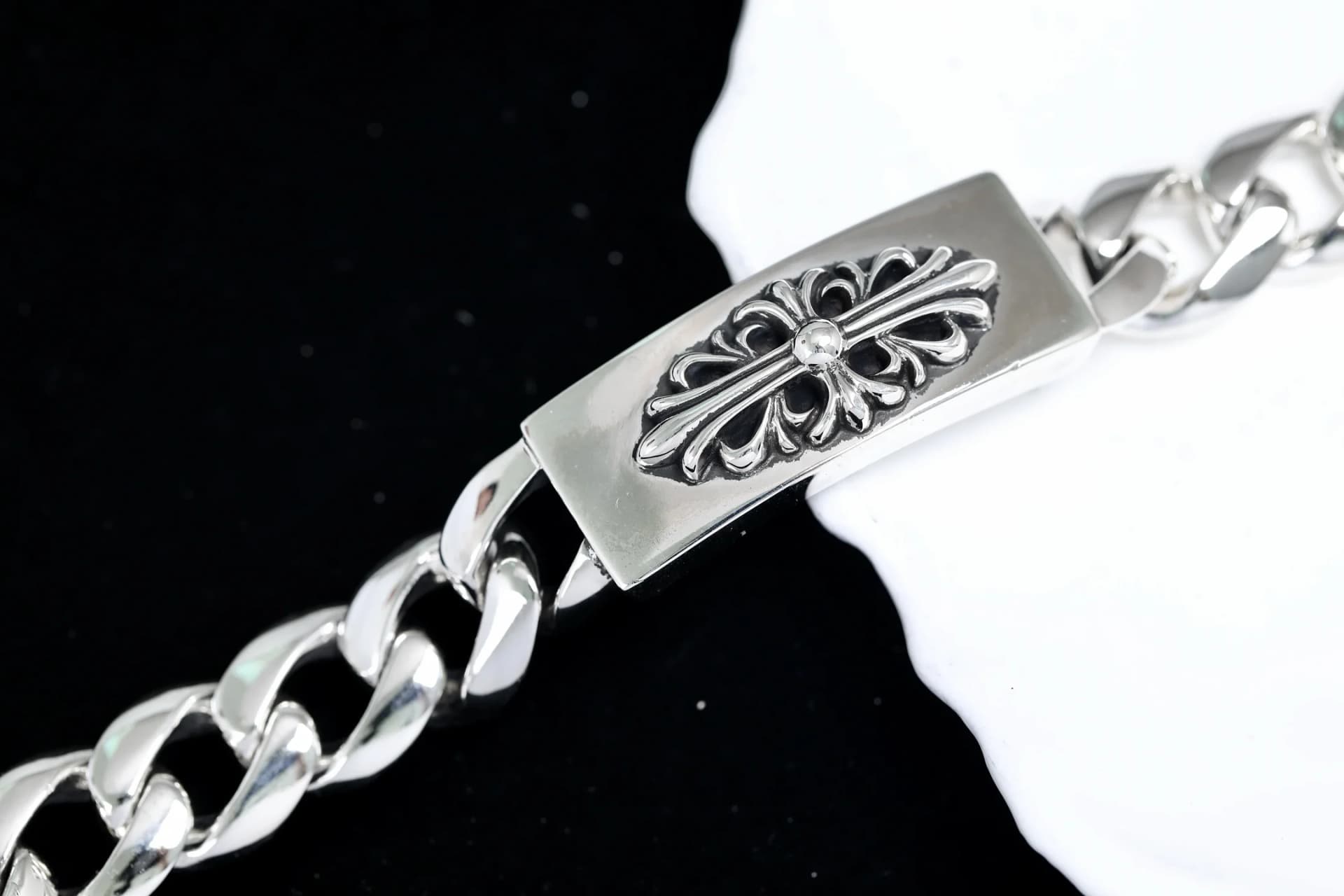 Крупный план серебряной пластины с рельефным цветочным крестом Floral Cross