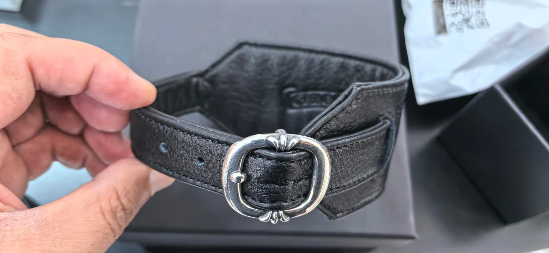 Кожаный аксессуар Chrome Hearts в руке, вид сверху