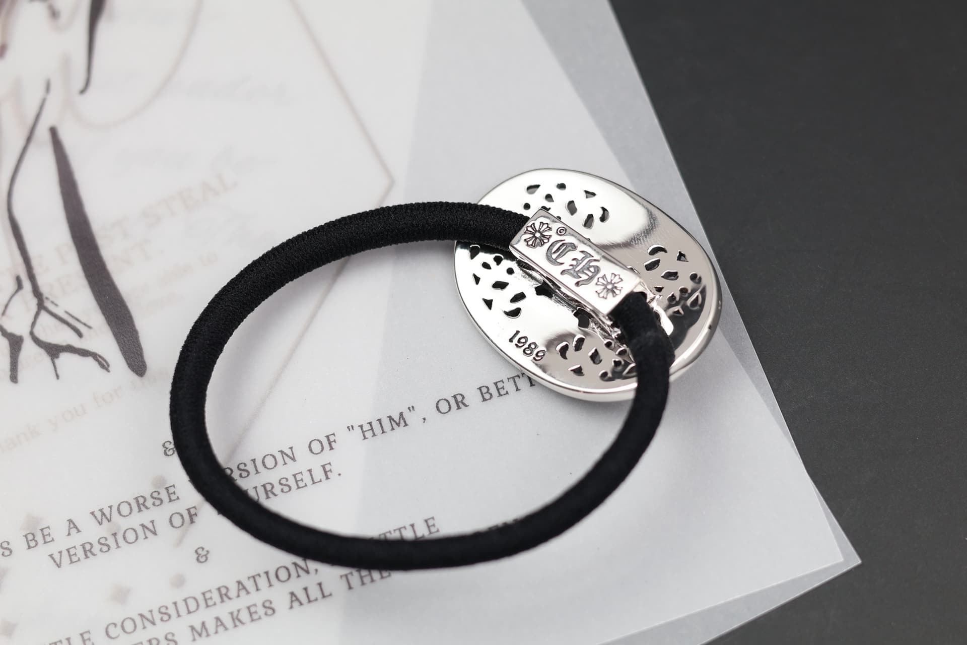 Оборотная сторона серебряной вставки резинки Chrome Hearts с фирменной гравировкой