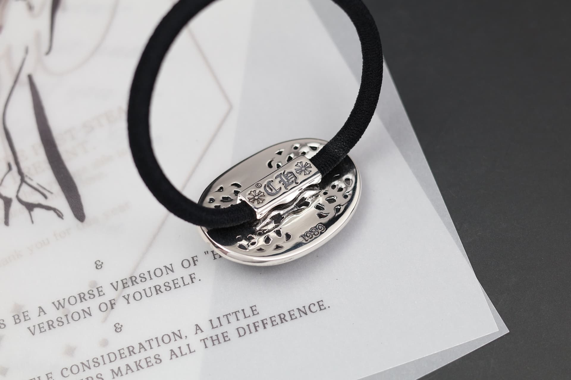 Крупный план фирменной гравировки Chrome Hearts на серебряной основе резинки