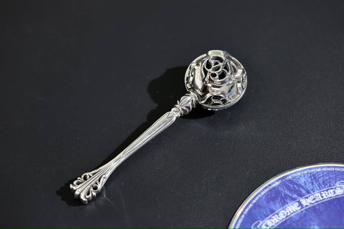 Серебряная детская погремушка Chrome Hearts Baby Rattle на темном фоне