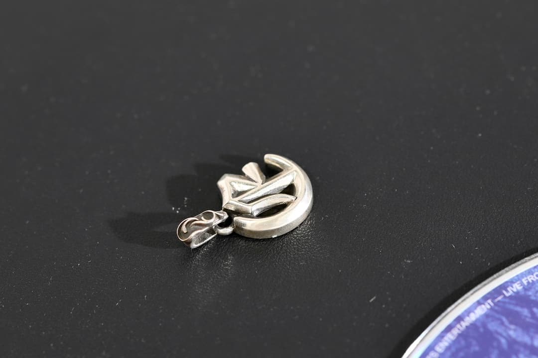 Объемный кулон буква E Chrome Hearts на темном фоне