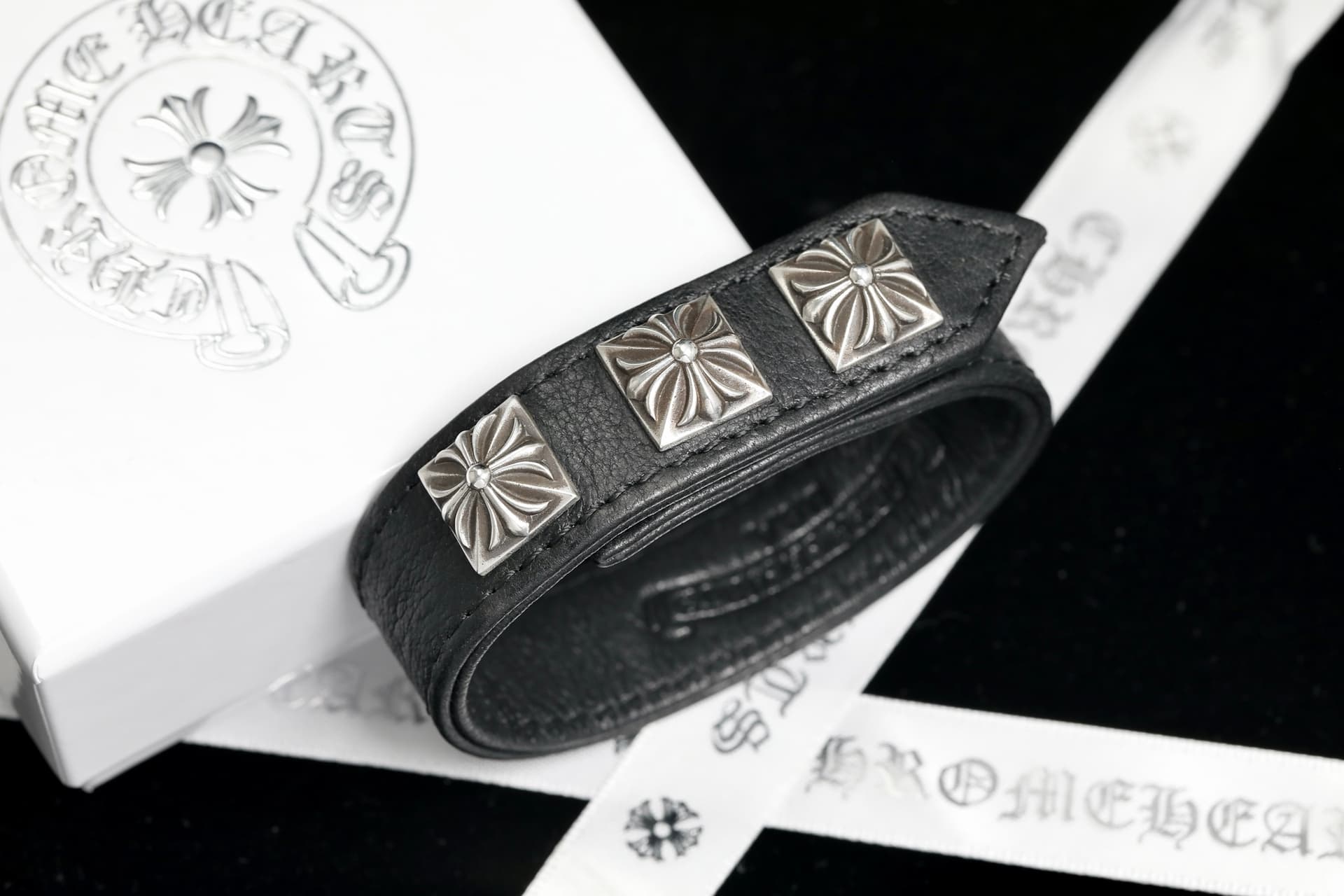 Кожаный браслет Chrome Hearts с квадратными серебряными заклепками рядом с брендовой упаковкой