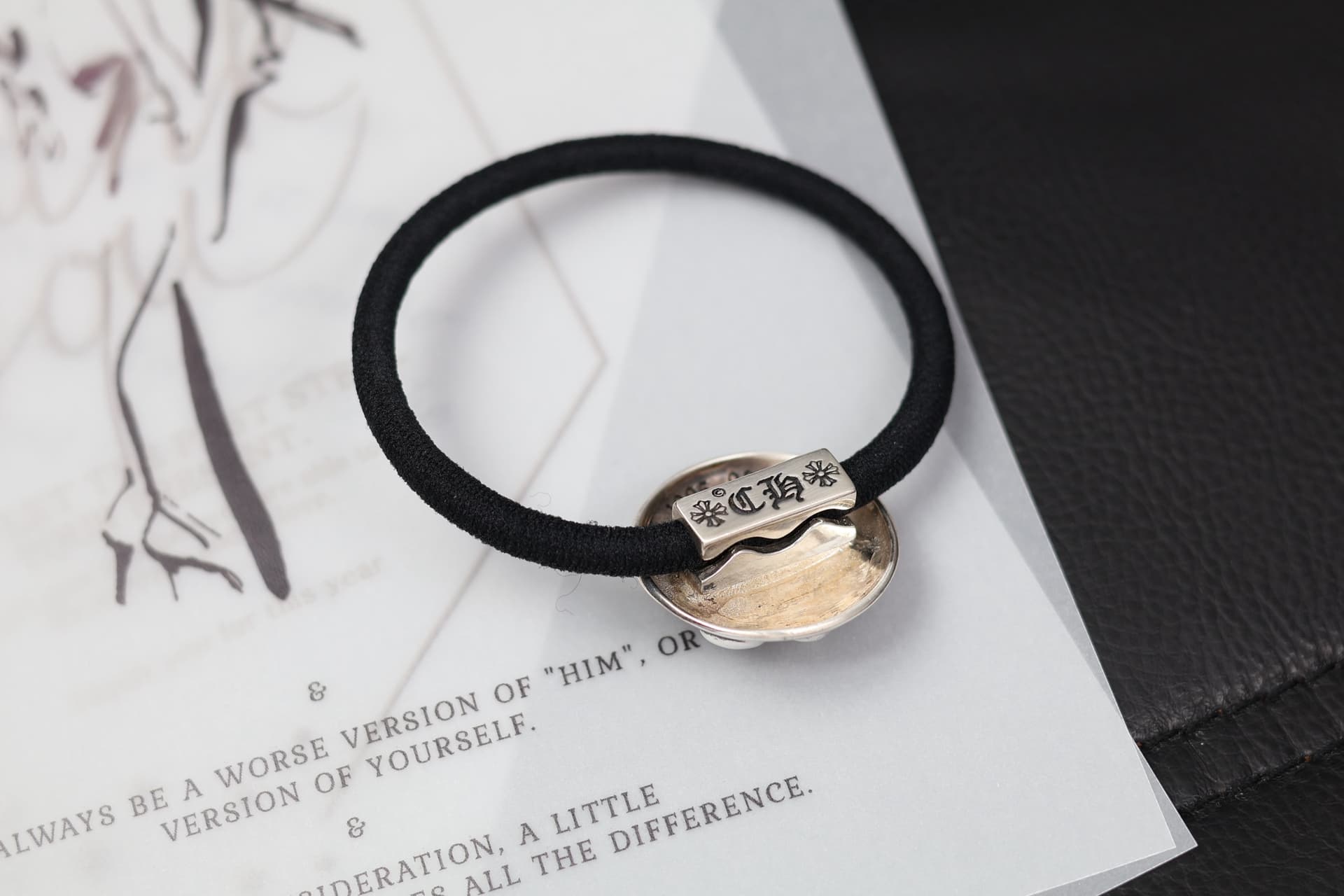Обратная сторона серебряной детали резинки для волос Chrome Hearts крупным планом