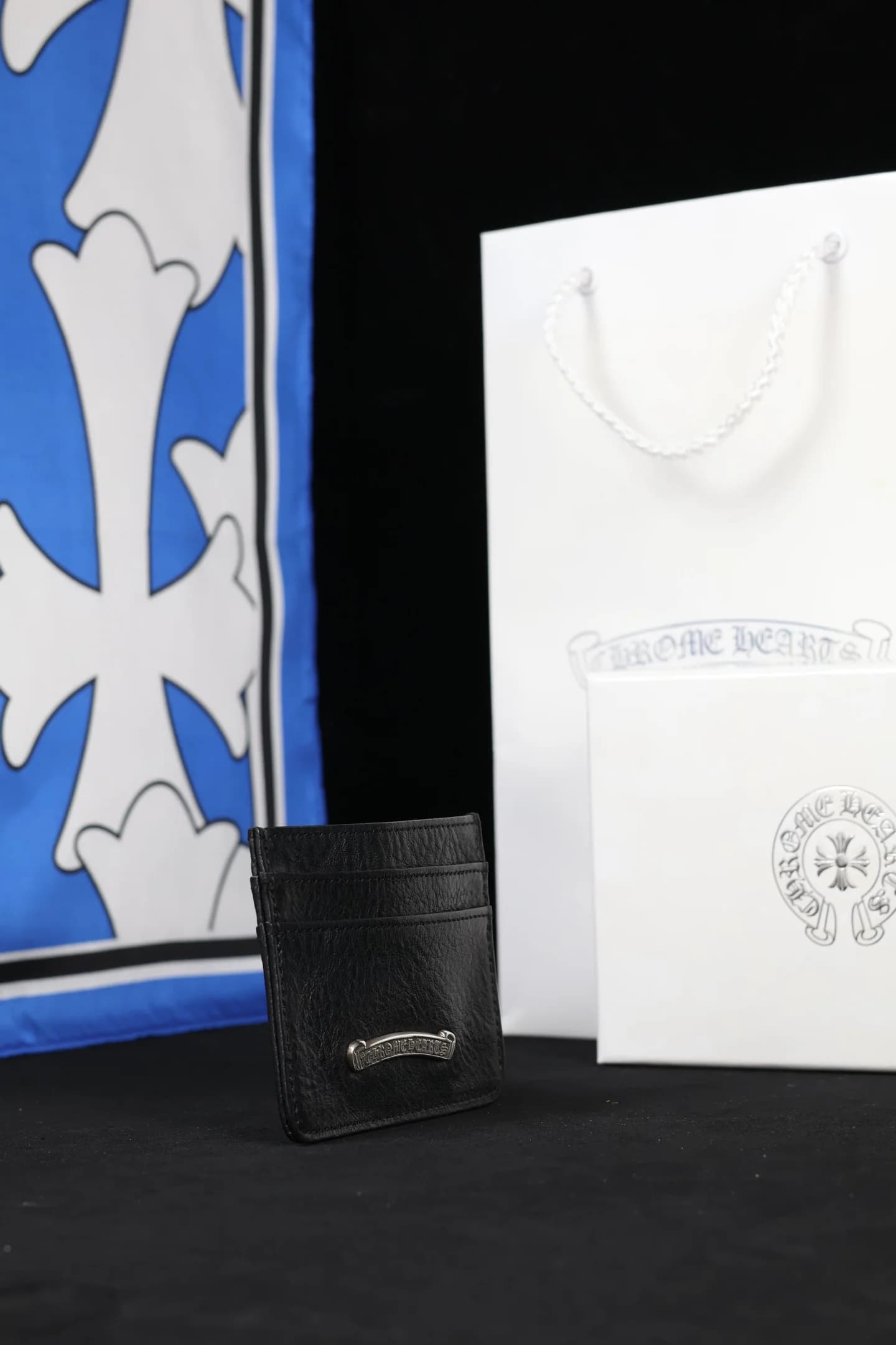 Кожаный картхолдер Chrome Hearts в полуобороте на тёмном фоне
