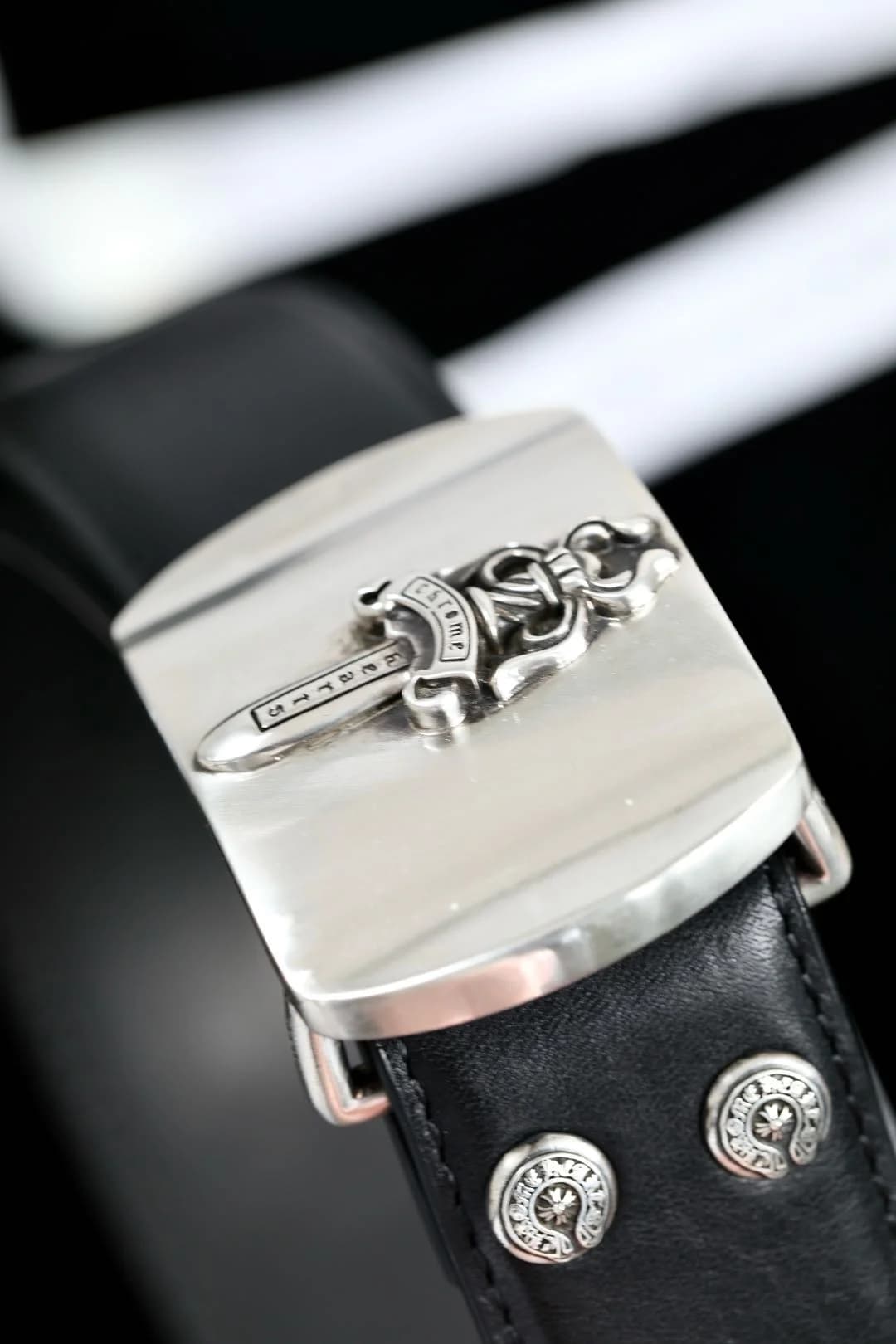 Крупный план серебряной пряжки Dagger 925 пробы и заклепок с крестами