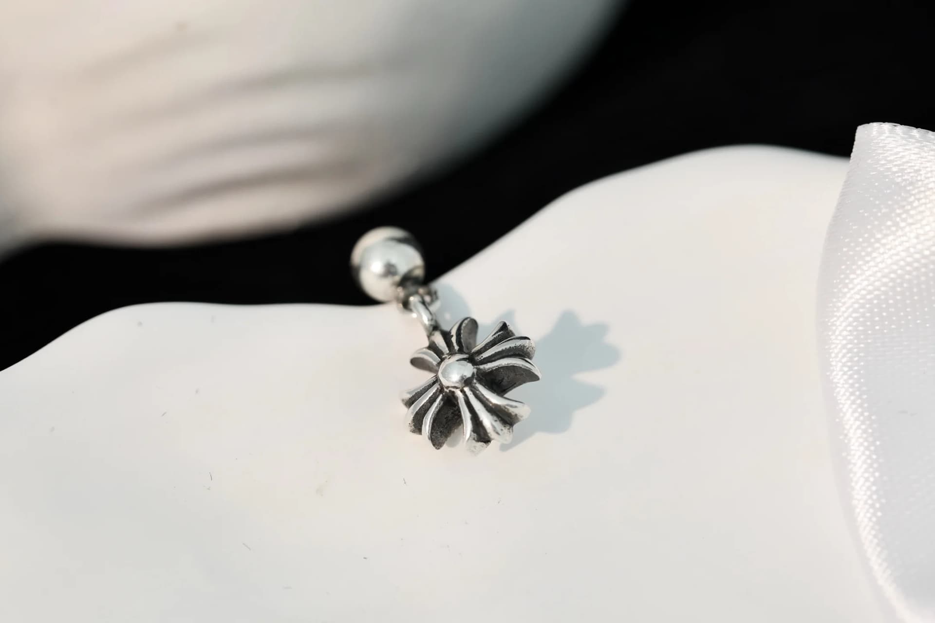 Крупный план подвесного креста серьги Chrome Hearts