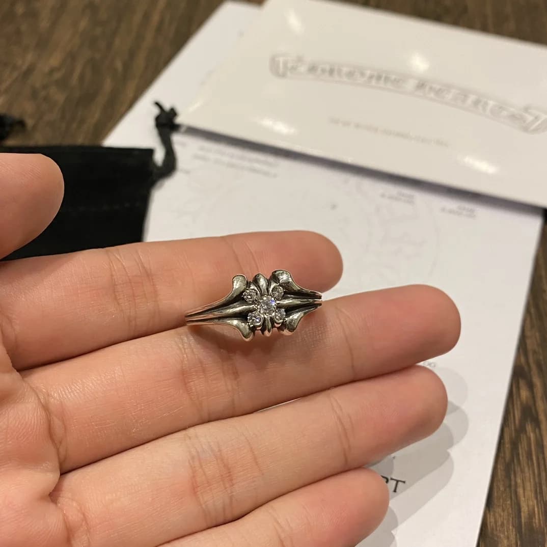 Кольцо в руке на фоне пыльника и квитанции Chrome Hearts