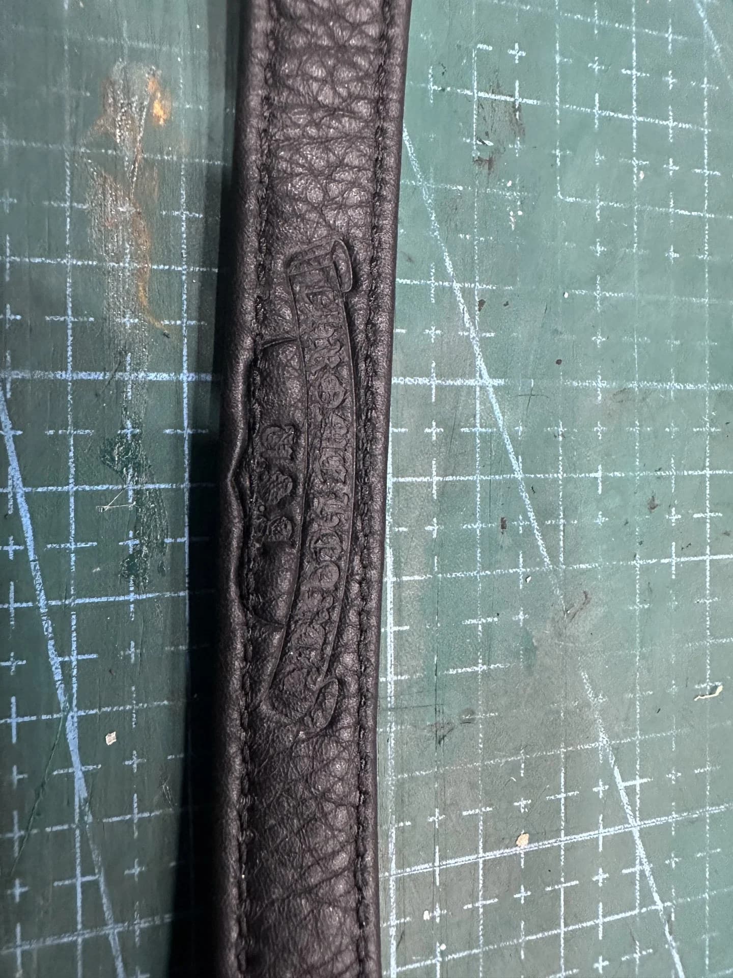 Тиснение фирменного логотипа на кожаном ремешке браслета Chrome Hearts