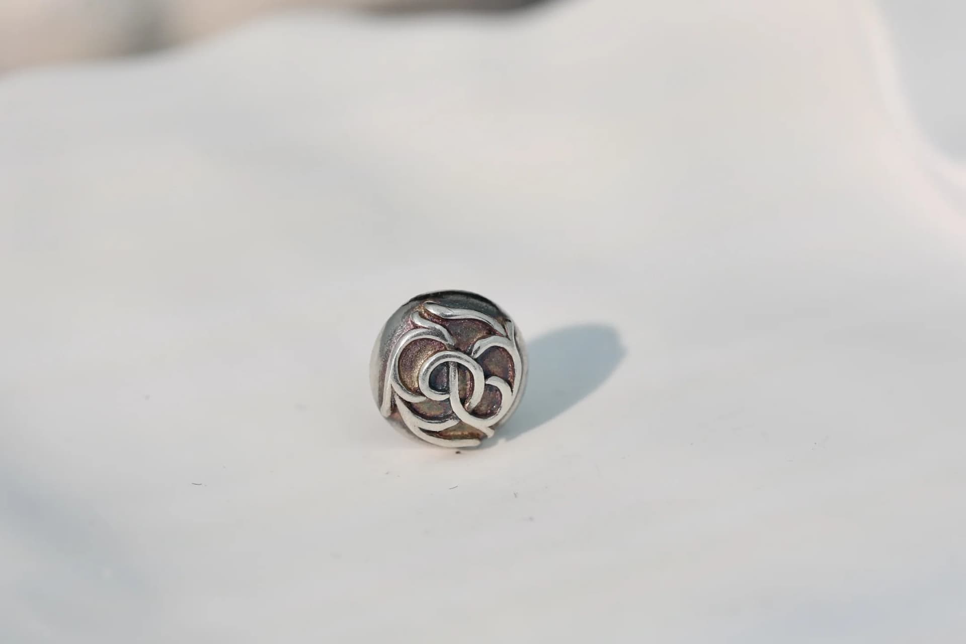 Фронтальный вид серебряной серьги-пусета Chrome Hearts с рельефным мотивом