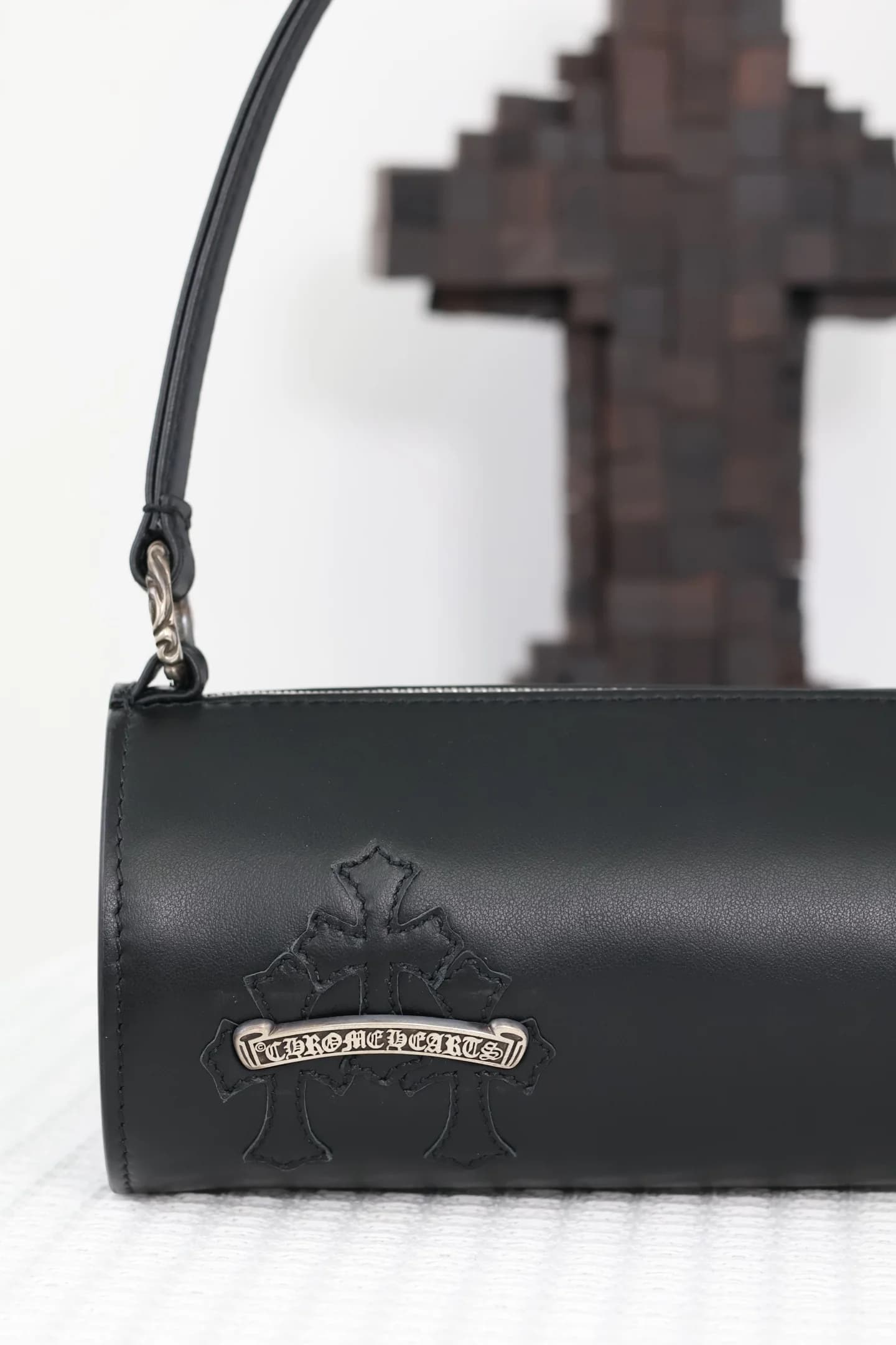 Крупный план корпуса сумки с кожаным крестом и серебряной планкой Chrome Hearts