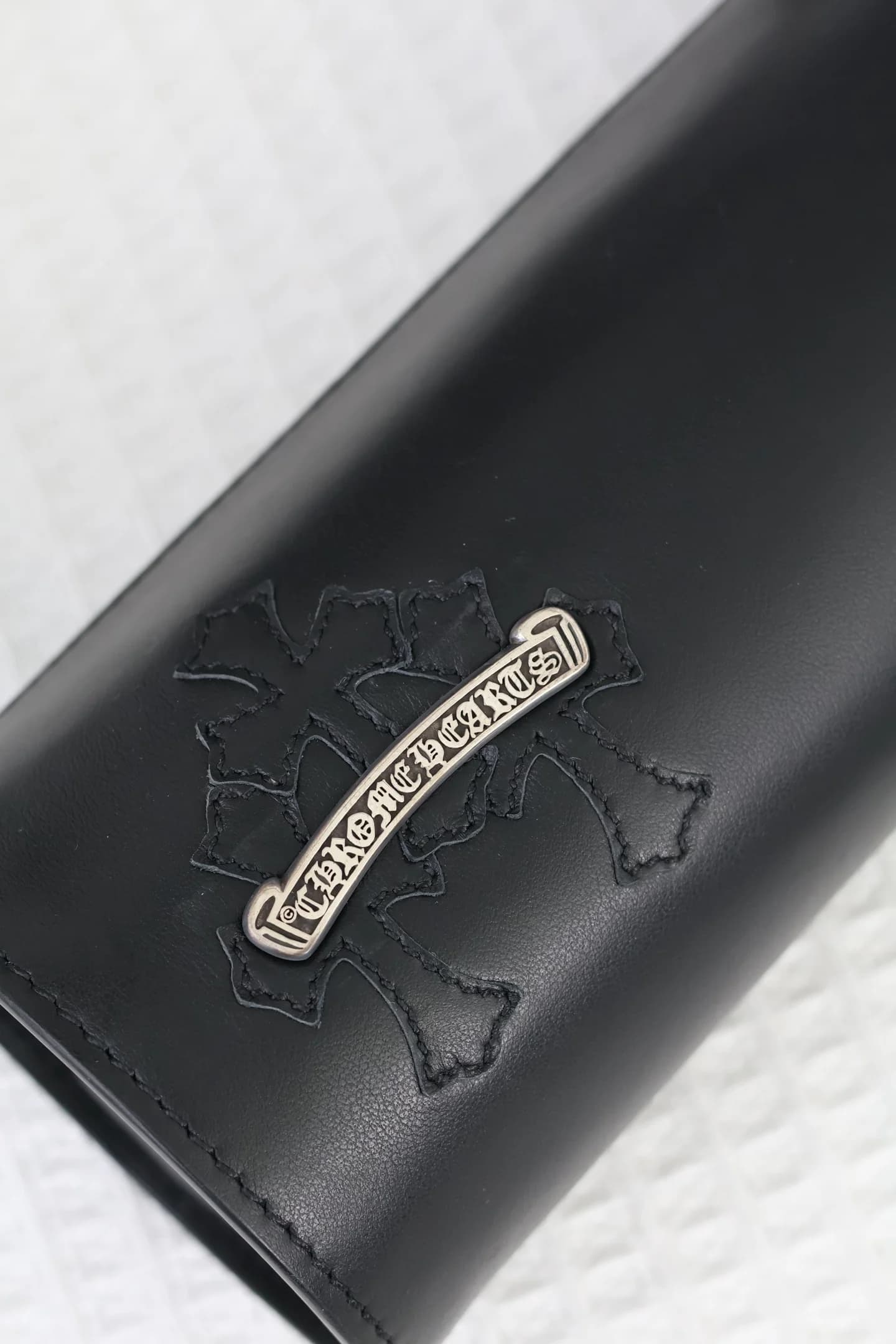 Деталь серебряной накладки с логотипом Chrome Hearts и прошитой аппликации