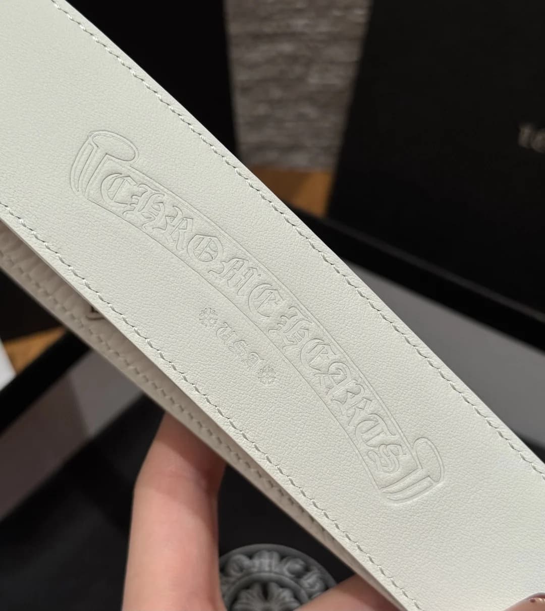 Тиснение логотипа Chrome Hearts на внутренней стороне белого кожаного ремня