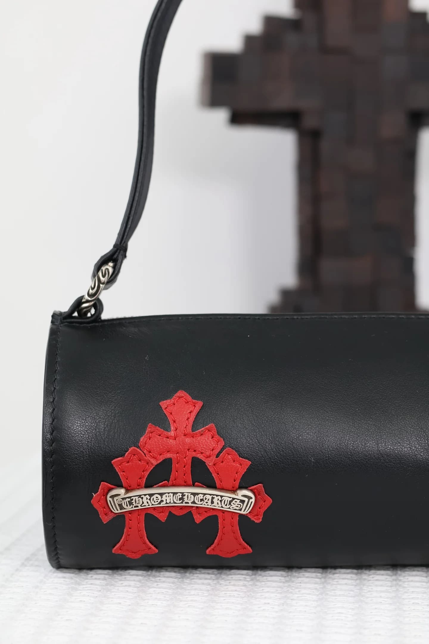 Крупный план красной нашивки с серебряной плашкой логотипа Chrome Hearts