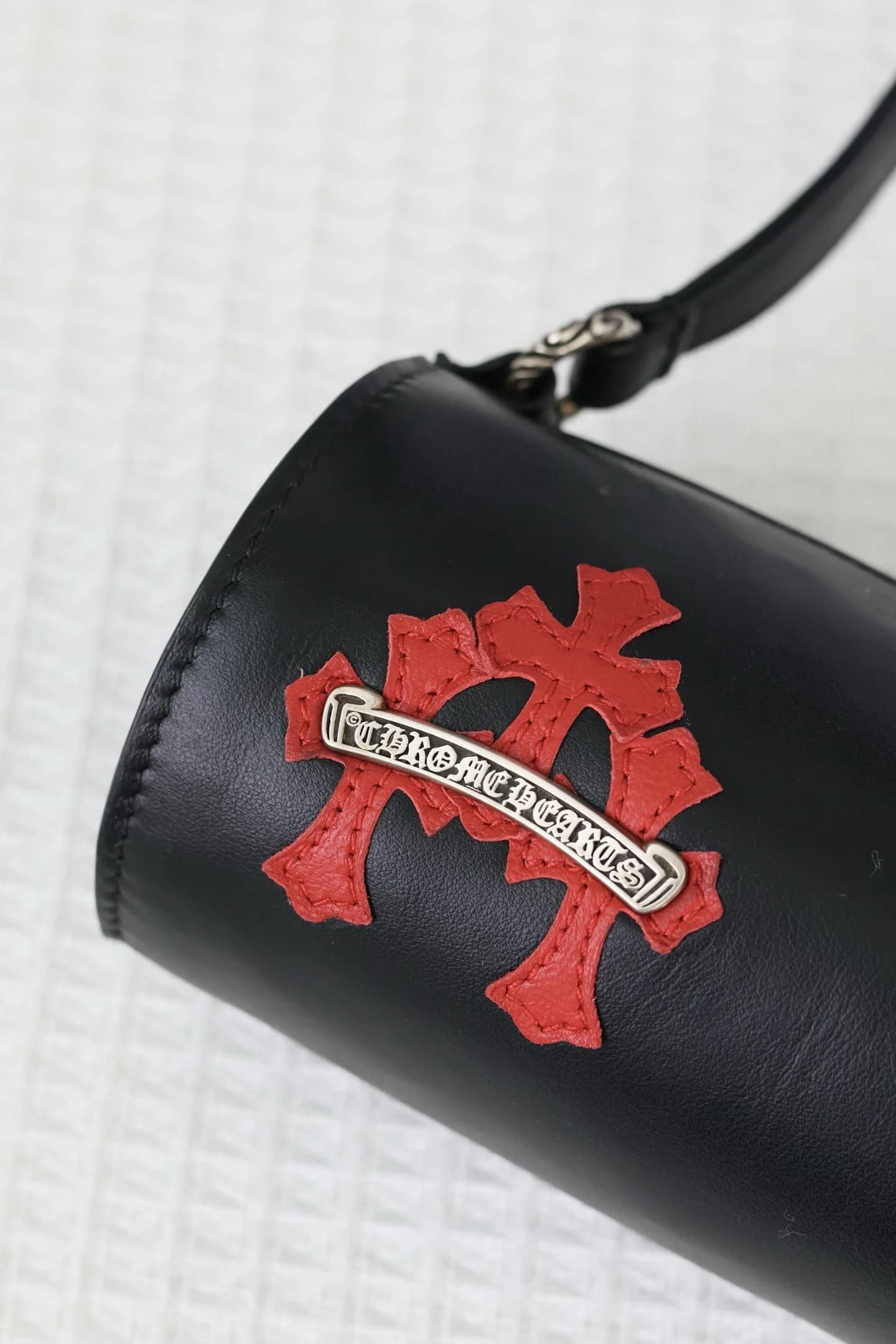 Фактура кожи и аппликация креста с гравировкой Chrome Hearts крупным планом