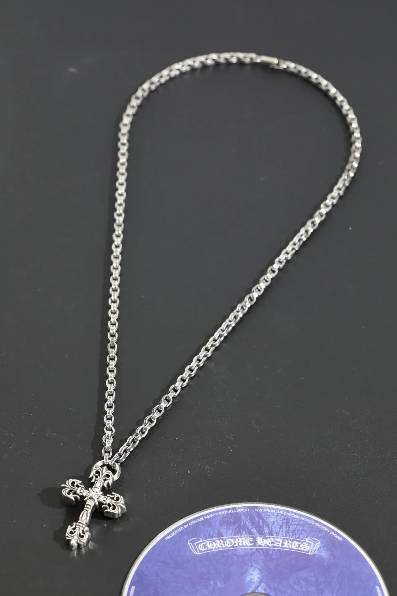 Серебряное колье Chrome Hearts с подвеской в виде креста на темном фоне
