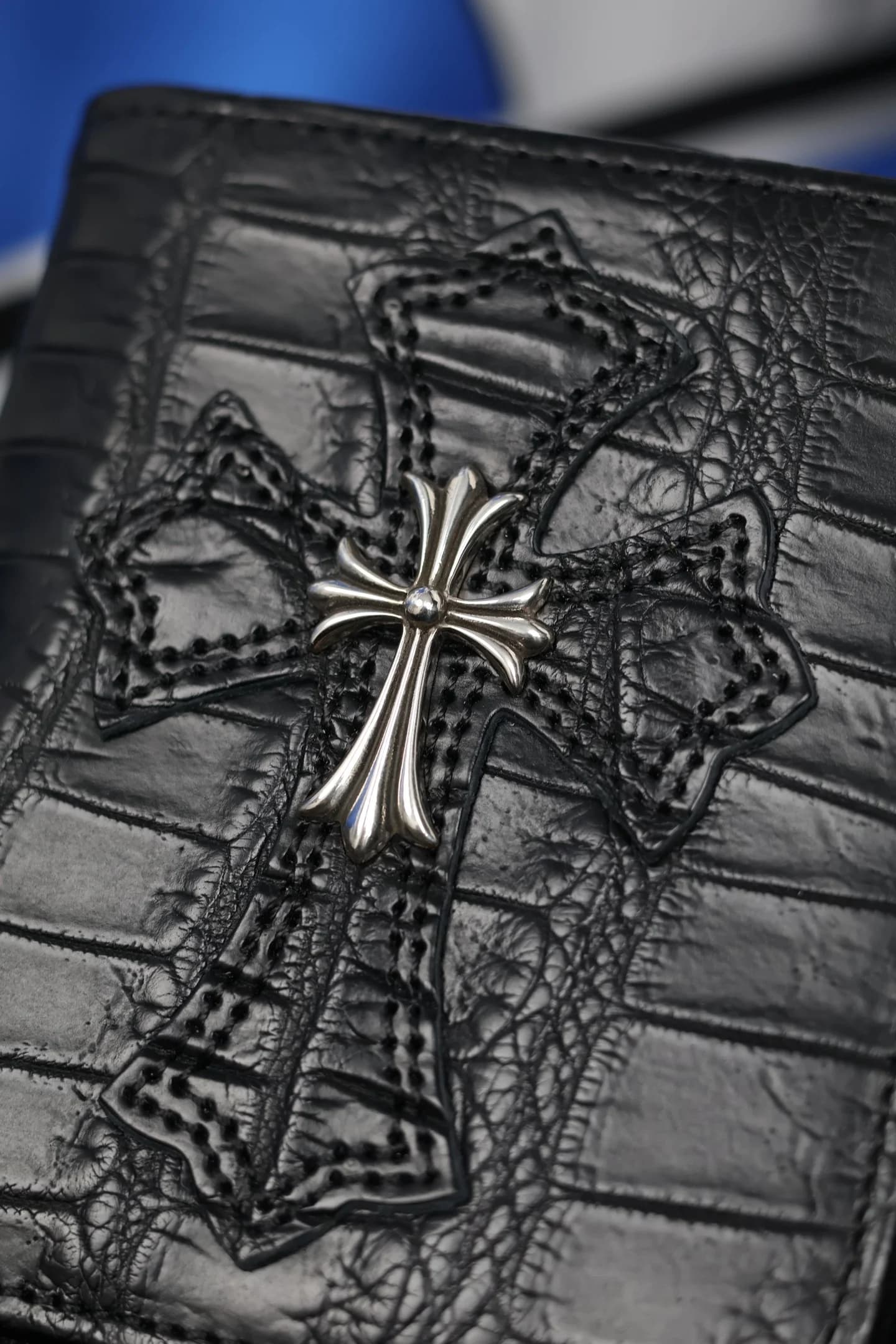 Крупный план кожаного креста с серебряной накладкой на кошельке Chrome Hearts