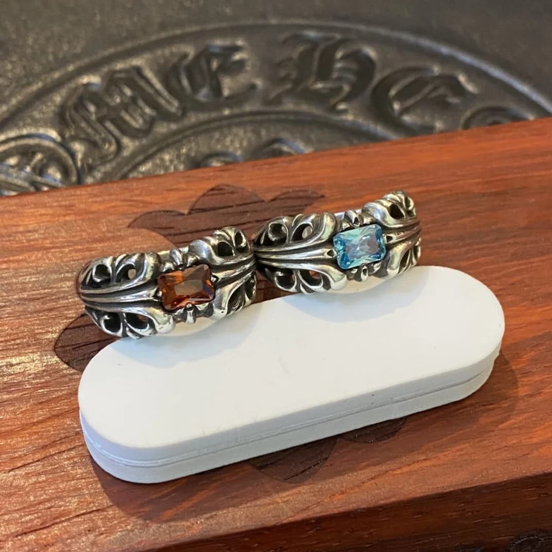 Два кольца Chrome Hearts с кристаллами разного цвета на подставке